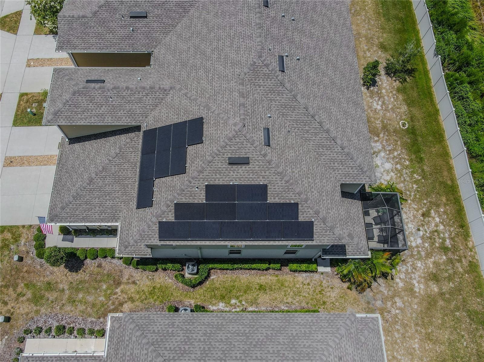 An aerial view highlights the home’s 2021 roof and full leased solar panel system, complete with battery backup-an energy-conscious upgrade thoughtfully integrated across multiple roof planes. - 3029 JACOB CROSSING LN, HOLIDAY