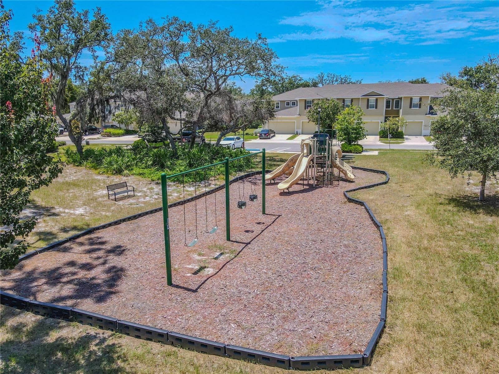 The community playground adds another neighborhood amenity, with swings, slides, climbing features and nearby bench seating in an open green setting. - 3029 JACOB CROSSING LN, HOLIDAY