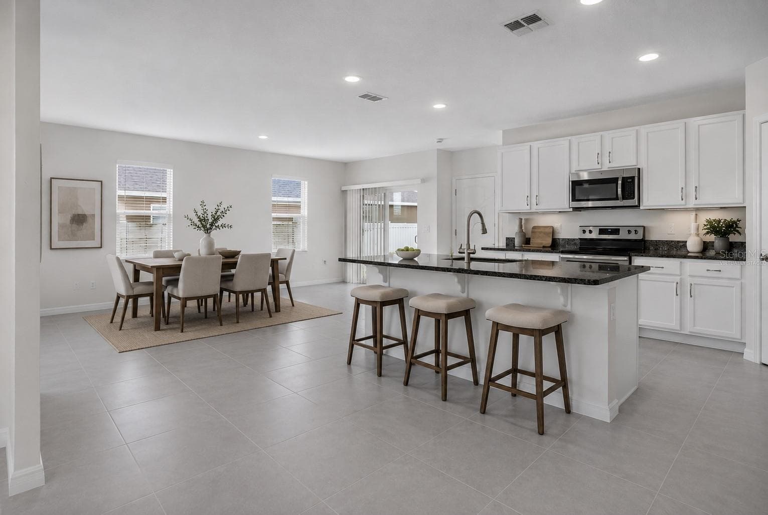 Virtually staged kitchen with granite countertops and large center island - 1021 SILVERBELL TRL, ST CLOUD