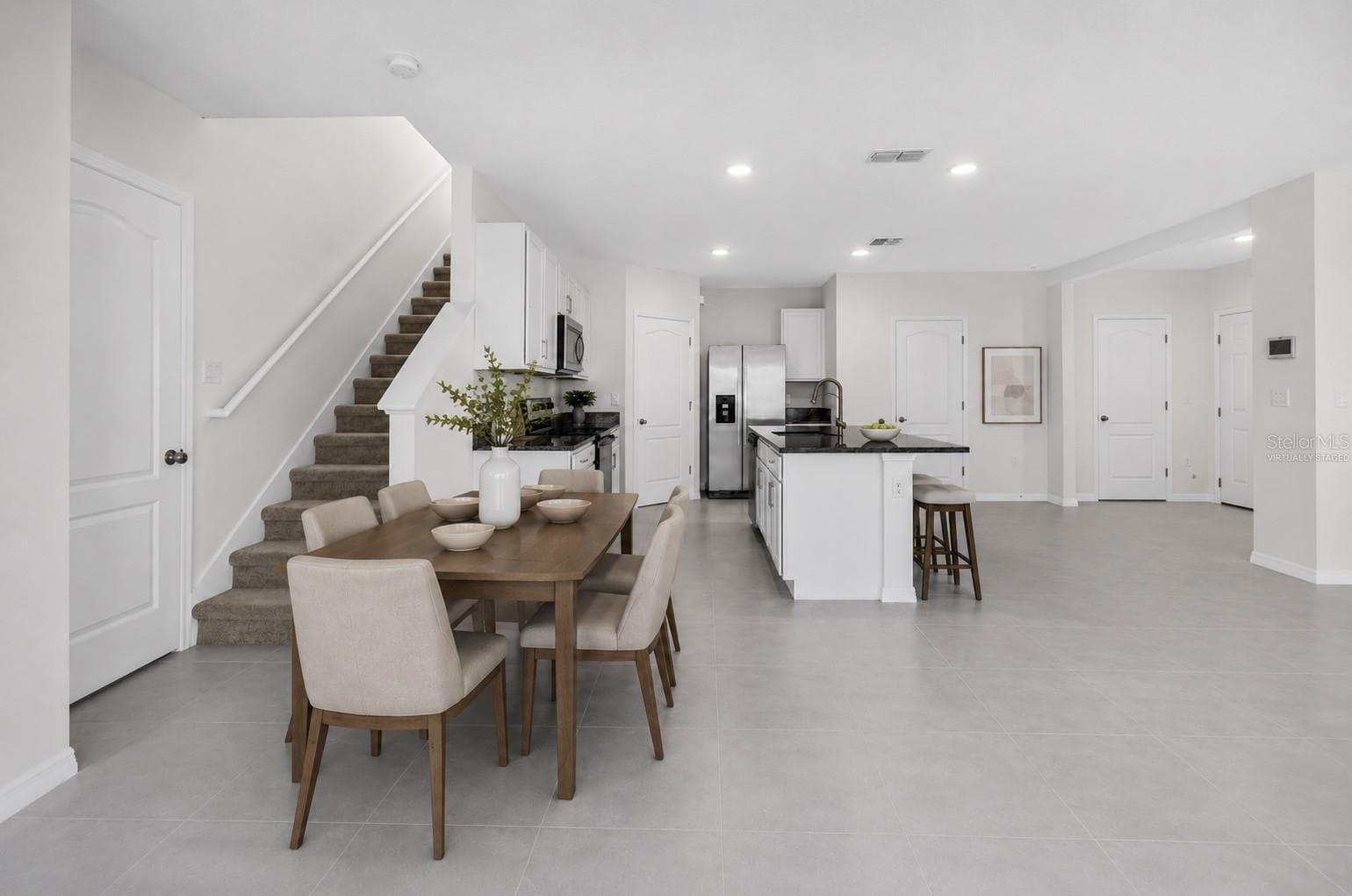Virtually staged dining area overlooking the open-concept kitchen - 1021 SILVERBELL TRL, ST CLOUD