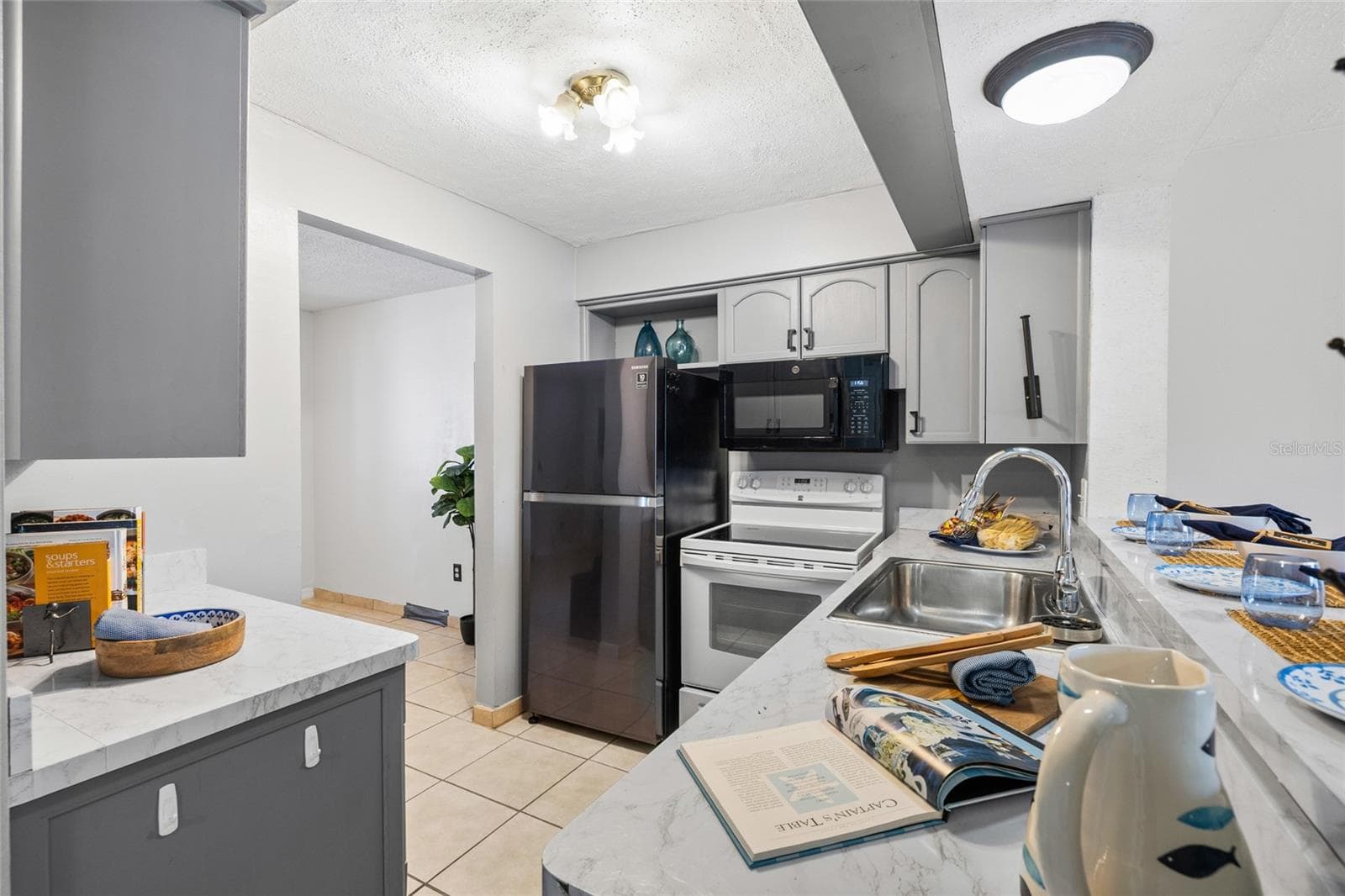 Kitchen enters to both the front room and the living/dining room - 4038 CORTEZ DR #B, TAMPA