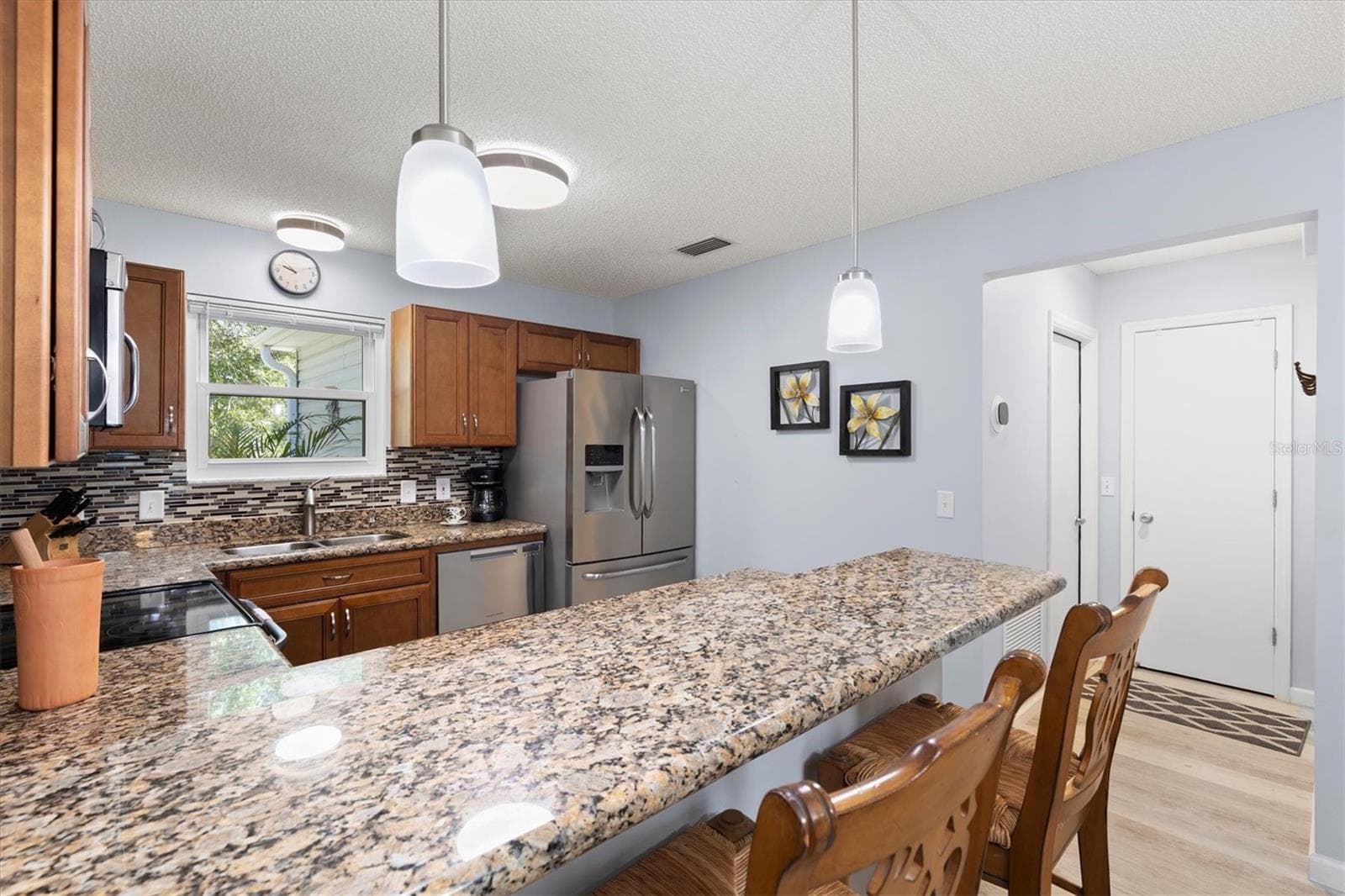 KITCHEN WITH GRANITE AND BAR STOOLS - 1426 JUAREZ PL, THE VILLAGES