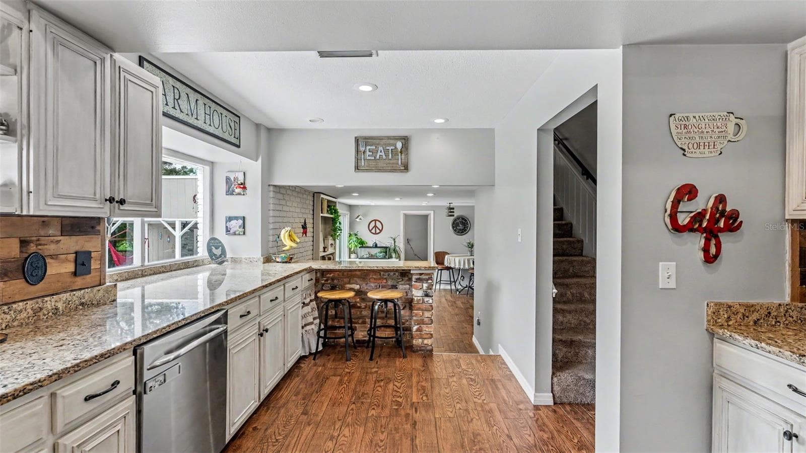 kitchen with bar stools and sitting area - 2406 LAKE ELLA RD, FRUITLAND PARK