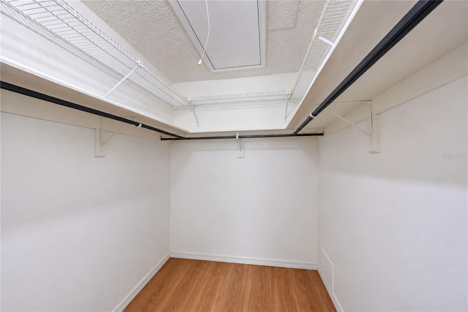 Primary bedroom walk-in closet with pull down stairs to attic - 9406 ANDOVER CIR, BRADENTON