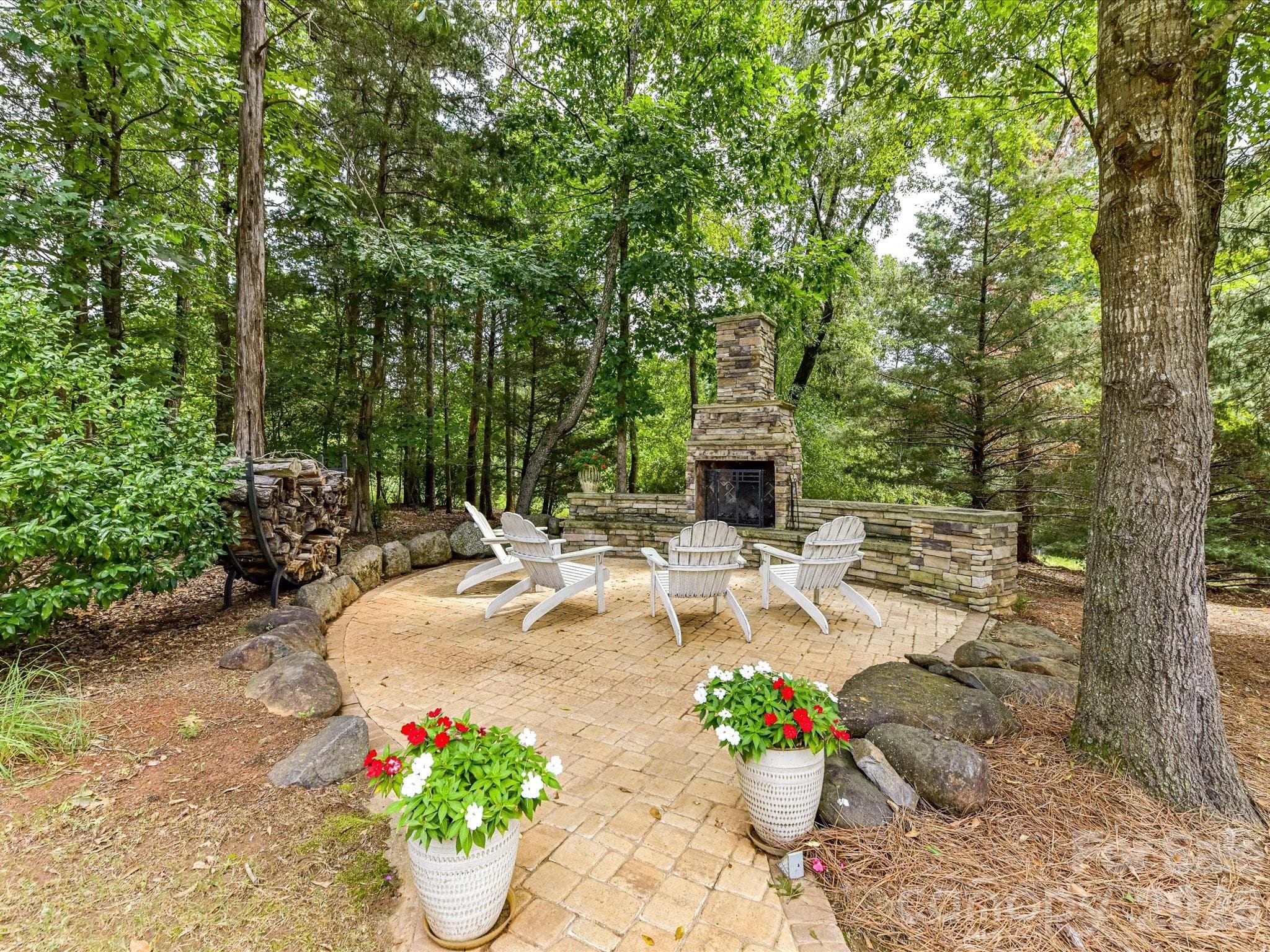 Such a lovely outdoor fireplace in the treed backyard. - 12323 Cherrybark Lane, Charlotte