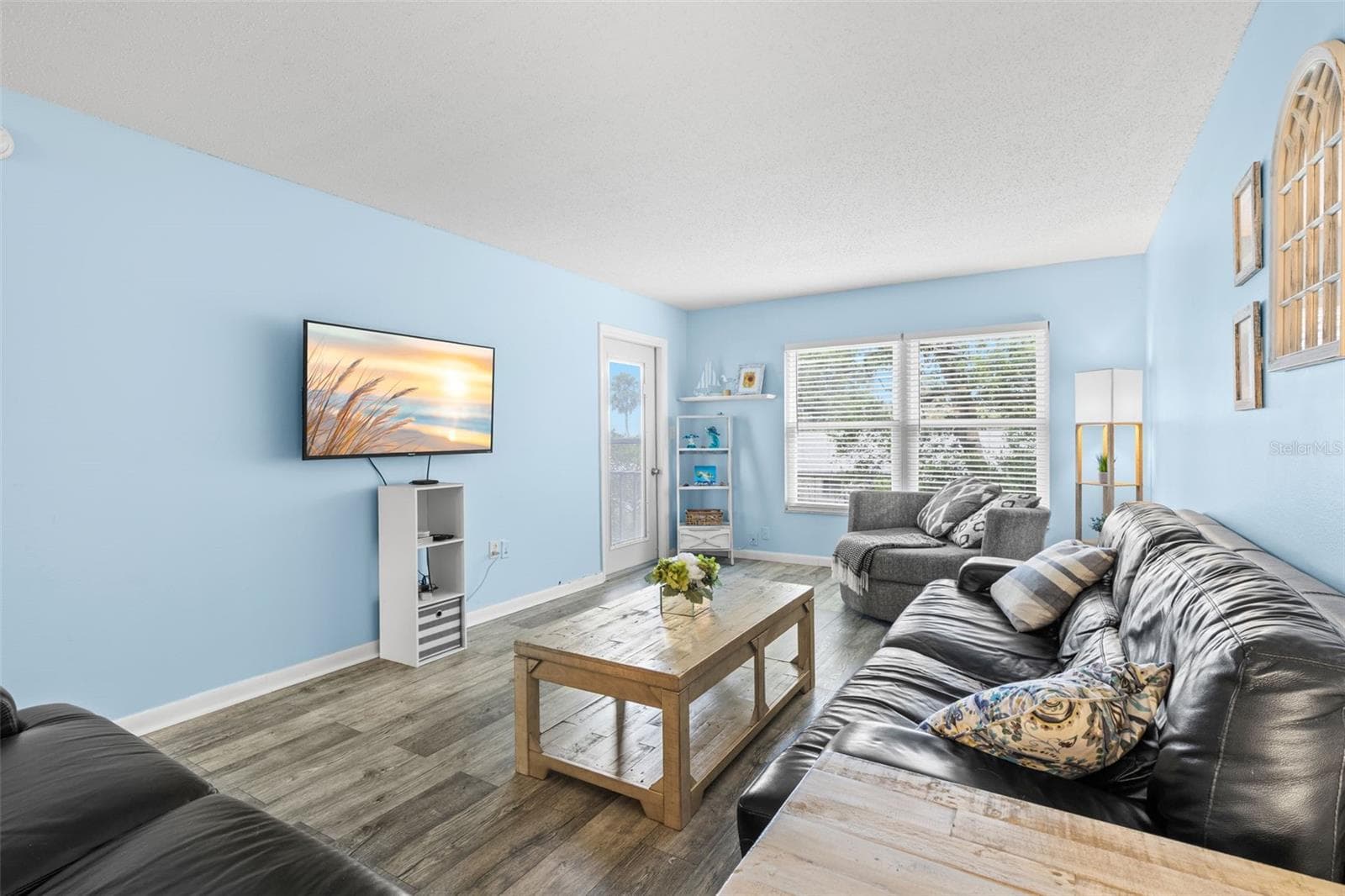 At the far end of the living room, a broad window and a door to the screened balcony bring in natural light, while the room’s long proportions leave plenty of space for substantial seating and media furniture. - 12760 INDIAN ROCKS RD #107, LARGO