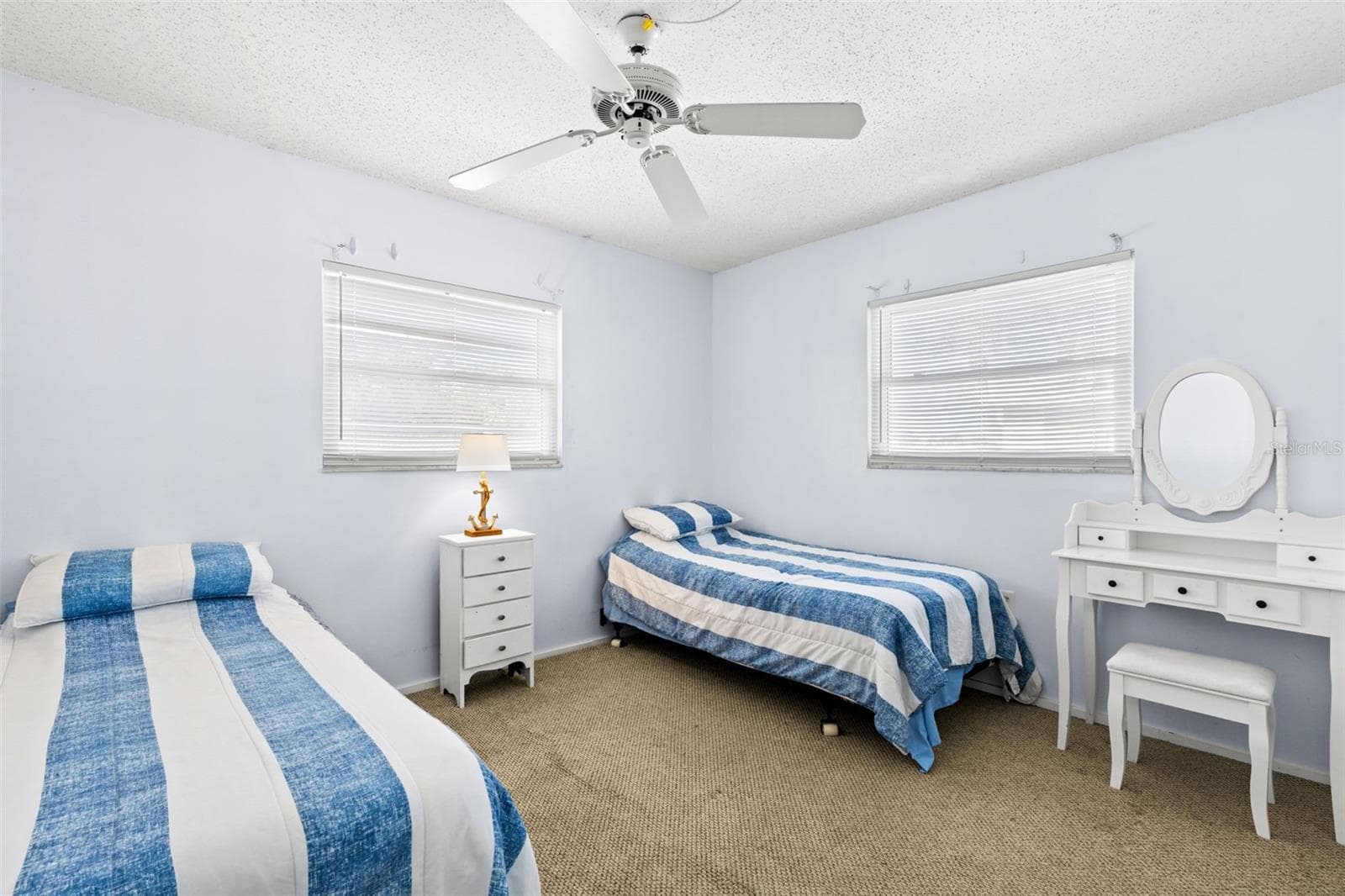 Bedroom 2 measures approximately 10'5" x 11'3", with neutral carpet, a ceiling fan and windows on two walls bringing in plenty of natural light. - 12760 INDIAN ROCKS RD #107, LARGO