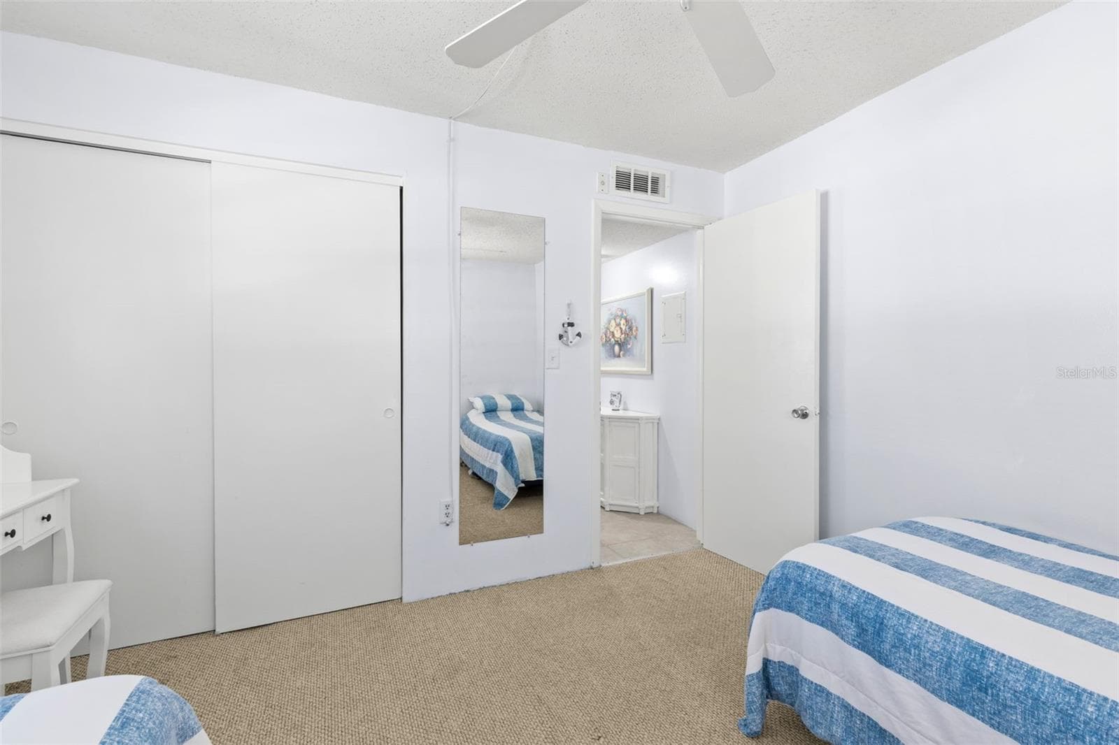 Bedroom 2 includes a built-in closet with sliding doors, neutral carpet and convenient access to the hall and nearby bath. - 12760 INDIAN ROCKS RD #107, LARGO