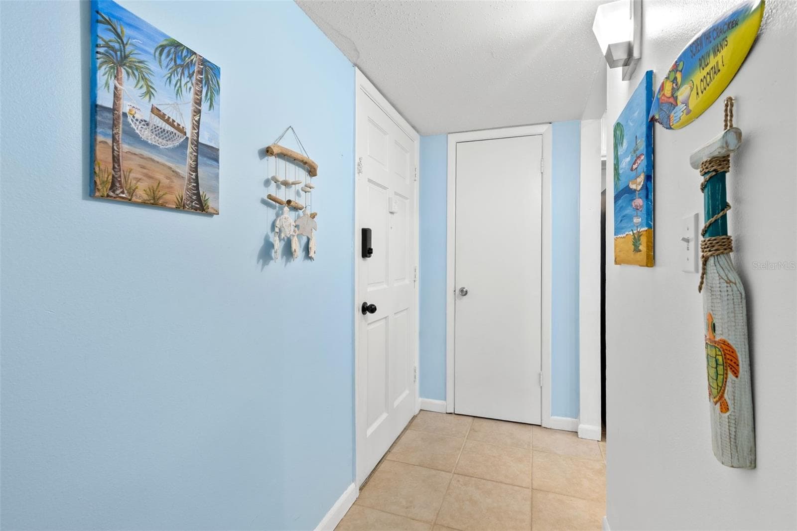 The tiled foyer creates a defined entry into the condo, with the front door opening to a compact hall that leads directly toward the kitchen and main living areas. - 12760 INDIAN ROCKS RD #107, LARGO