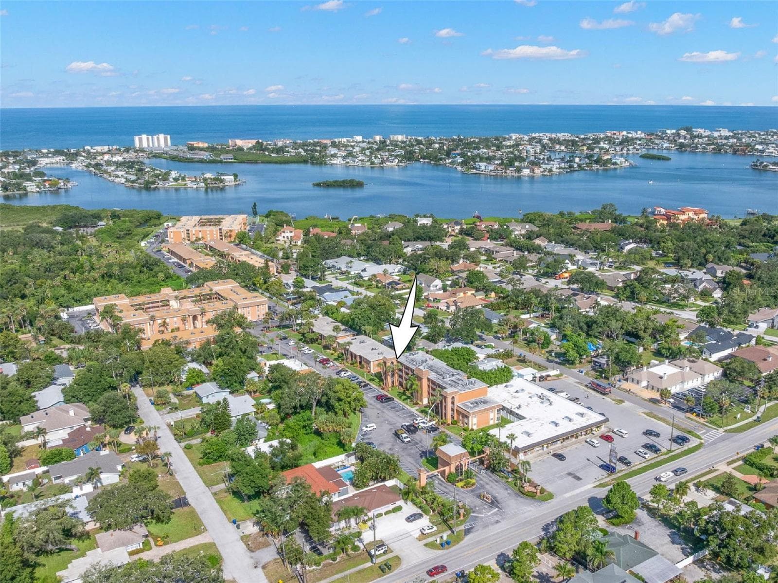 The community’s location comes into focus from above, with the Intracoastal Waterway and Gulf of Mexico stretching across the horizon and Indian Rocks Beach just beyond. - 12760 INDIAN ROCKS RD #107, LARGO