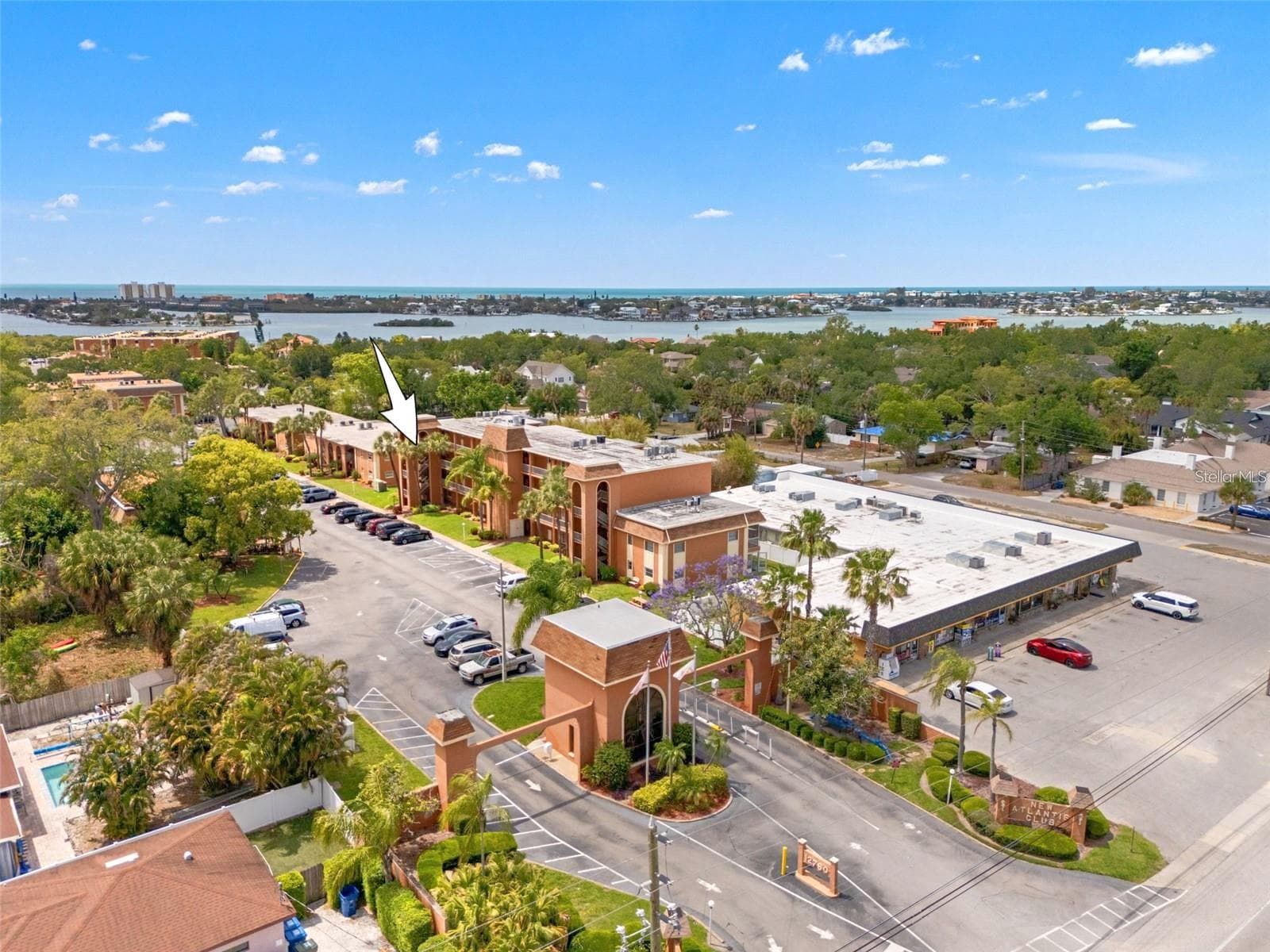 The landscaped entrance to New Atlantis Club creates a defined arrival, with a gated entry, tropical plantings and the community’s signature architectural details setting the tone from the start. - 12760 INDIAN ROCKS RD #107, LARGO