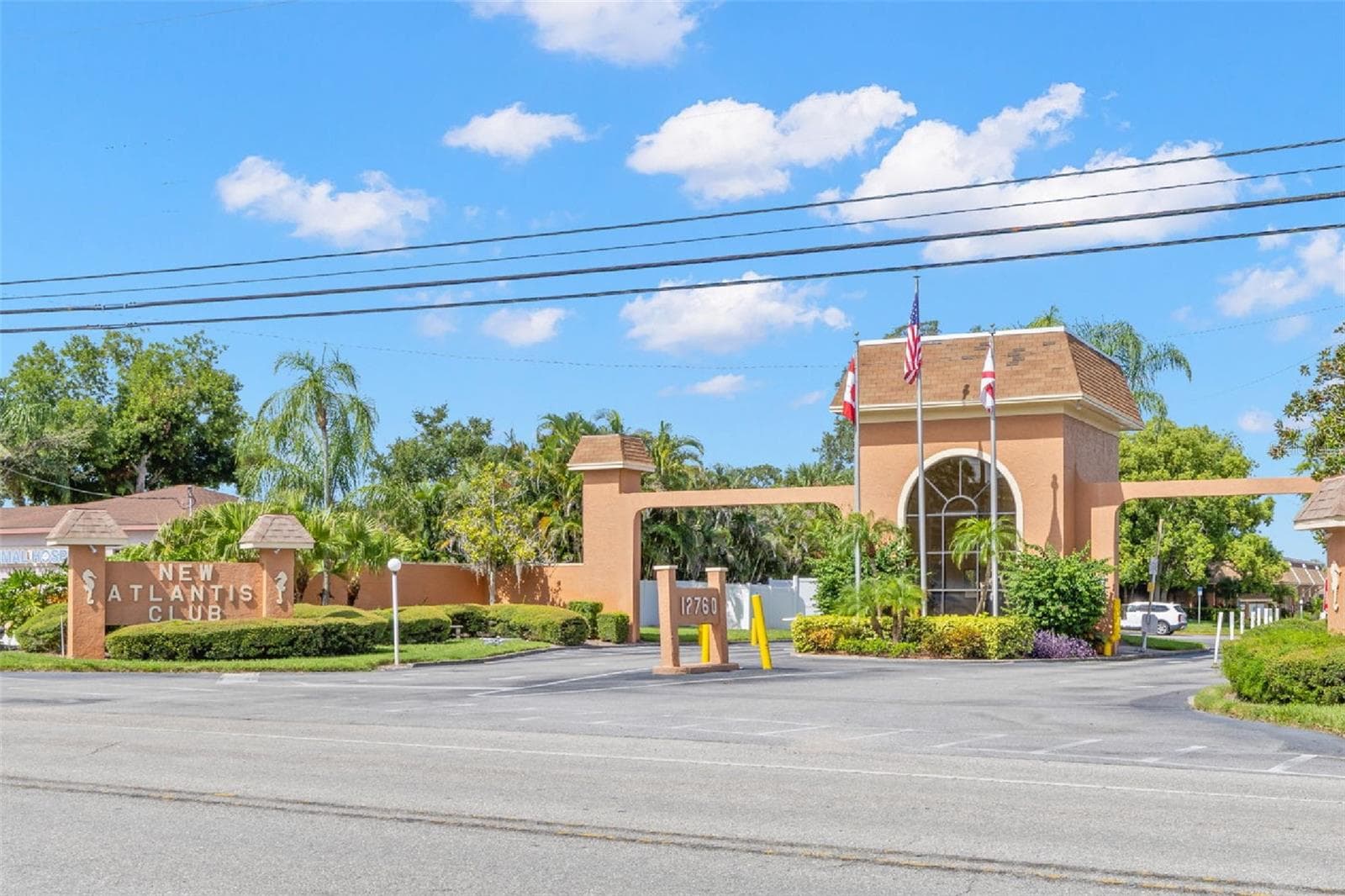 The landscaped entrance to New Atlantis Club creates a defined arrival, with a gated entry, tropical plantings and the community’s signature architectural details setting the tone from the start. - 12760 INDIAN ROCKS RD #107, LARGO