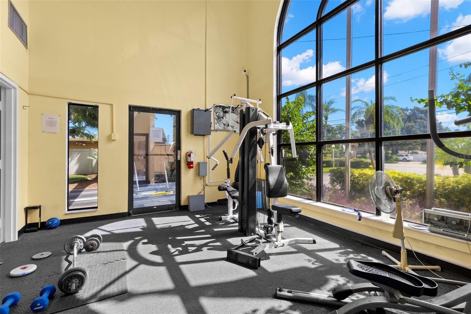Tall arched windows fill the fitness center with natural light, while open floor space and a mix of strength-training equipment add flexibility to the community workout area. - 12760 INDIAN ROCKS RD #107, LARGO