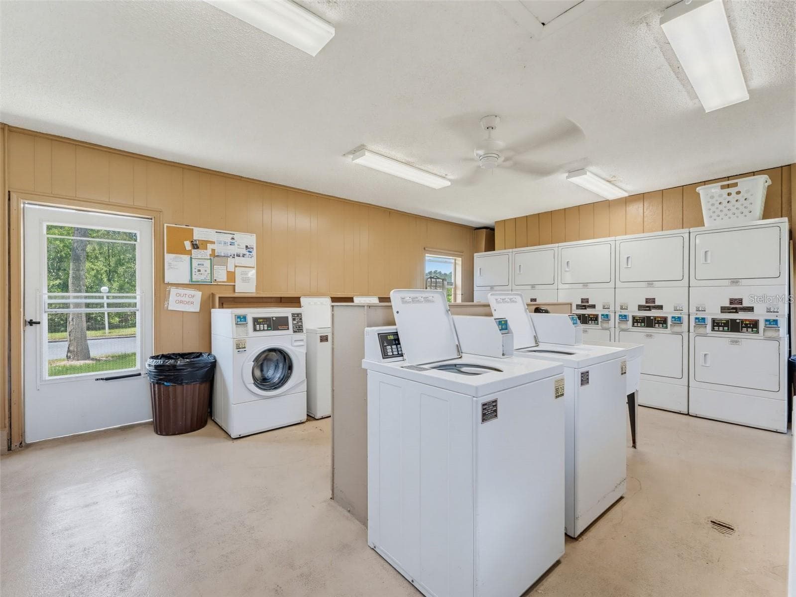 The community laundry room is equipped with multiple washers and dryers, providing a convenient shared option for residents within New Atlantis Club. - 12760 INDIAN ROCKS RD #107, LARGO