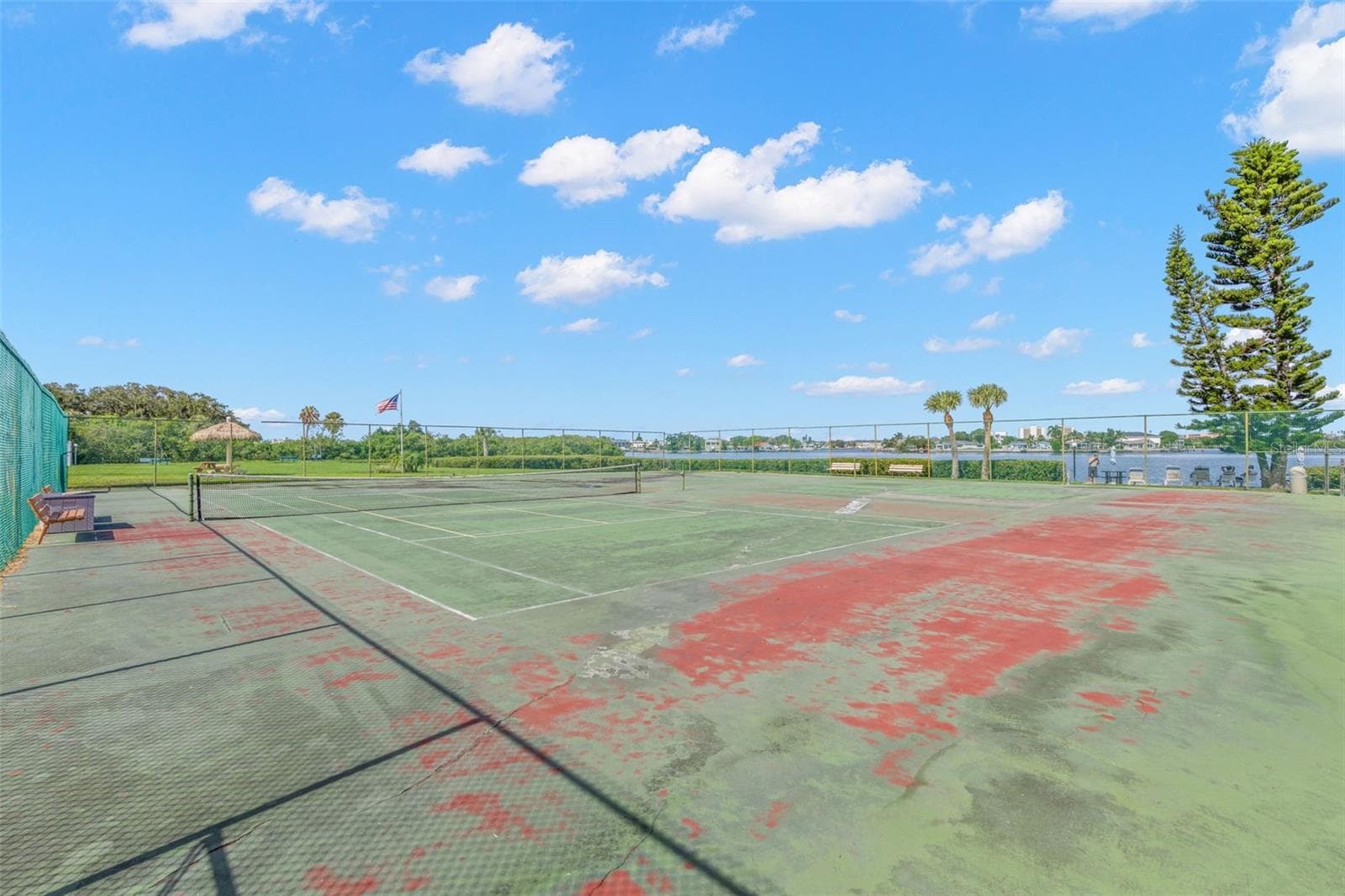 The community tennis courts sit beside the water, pairing another recreational amenity with open views across the surrounding mangroves and Intracoastal setting. - 12760 INDIAN ROCKS RD #107, LARGO