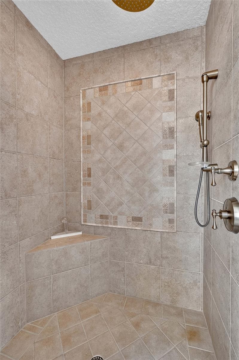 A built-in shower seat adds another thoughtful touch to this well-appointed primary bath. - 303 YACHT HARBOR DR, PALM COAST