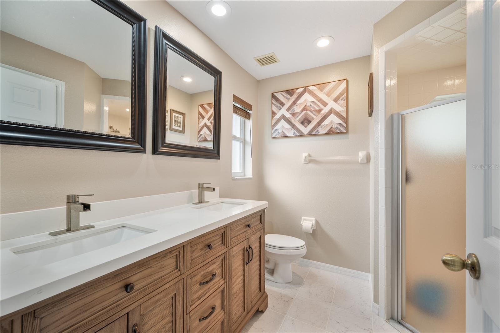 Primary bedroom ensuite with walk in shower and dual vanities! - 1660 GAMEWELL TRL, LAKELAND