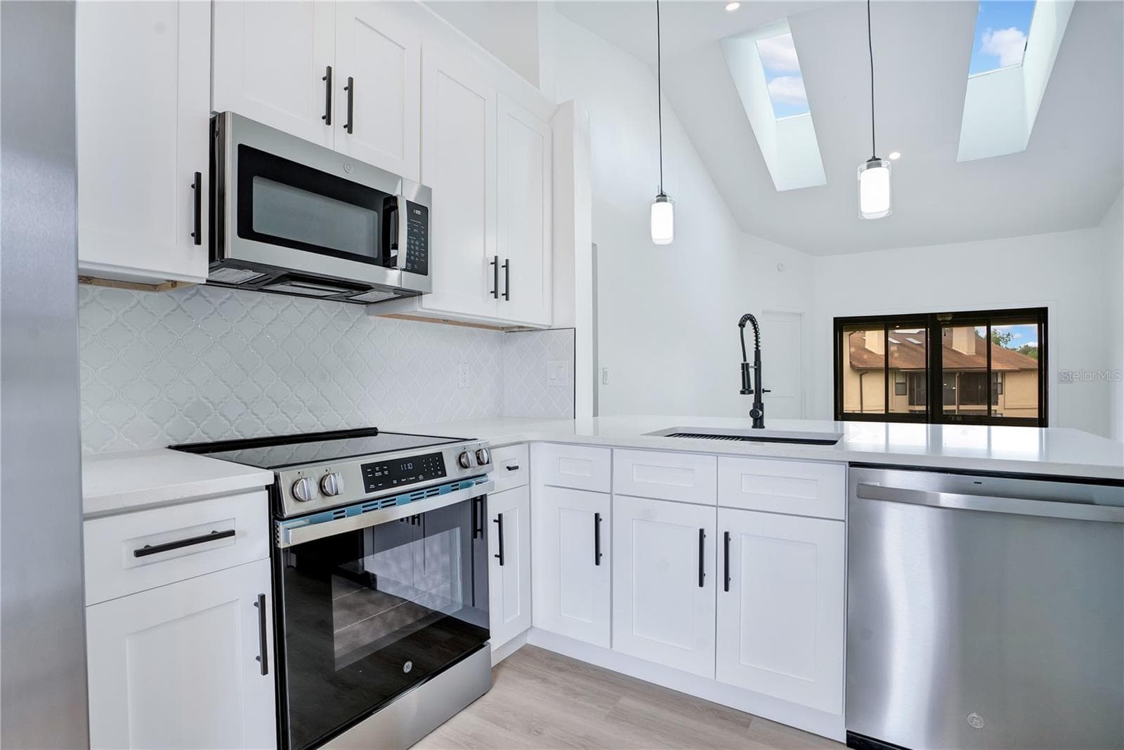 Fully remodeled kitchen featuring new shaker-style cabinetry, quartz countertops and modern finishes. - 3012 S SEMORAN BLVD #G2, ORLANDO