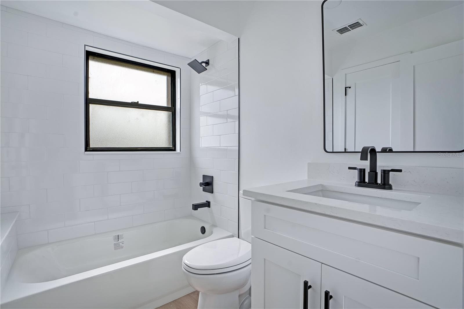 Beautifully renovated bathroom with tiled tub/shower combination and stylish modern finishes. - 3012 S SEMORAN BLVD #G2, ORLANDO