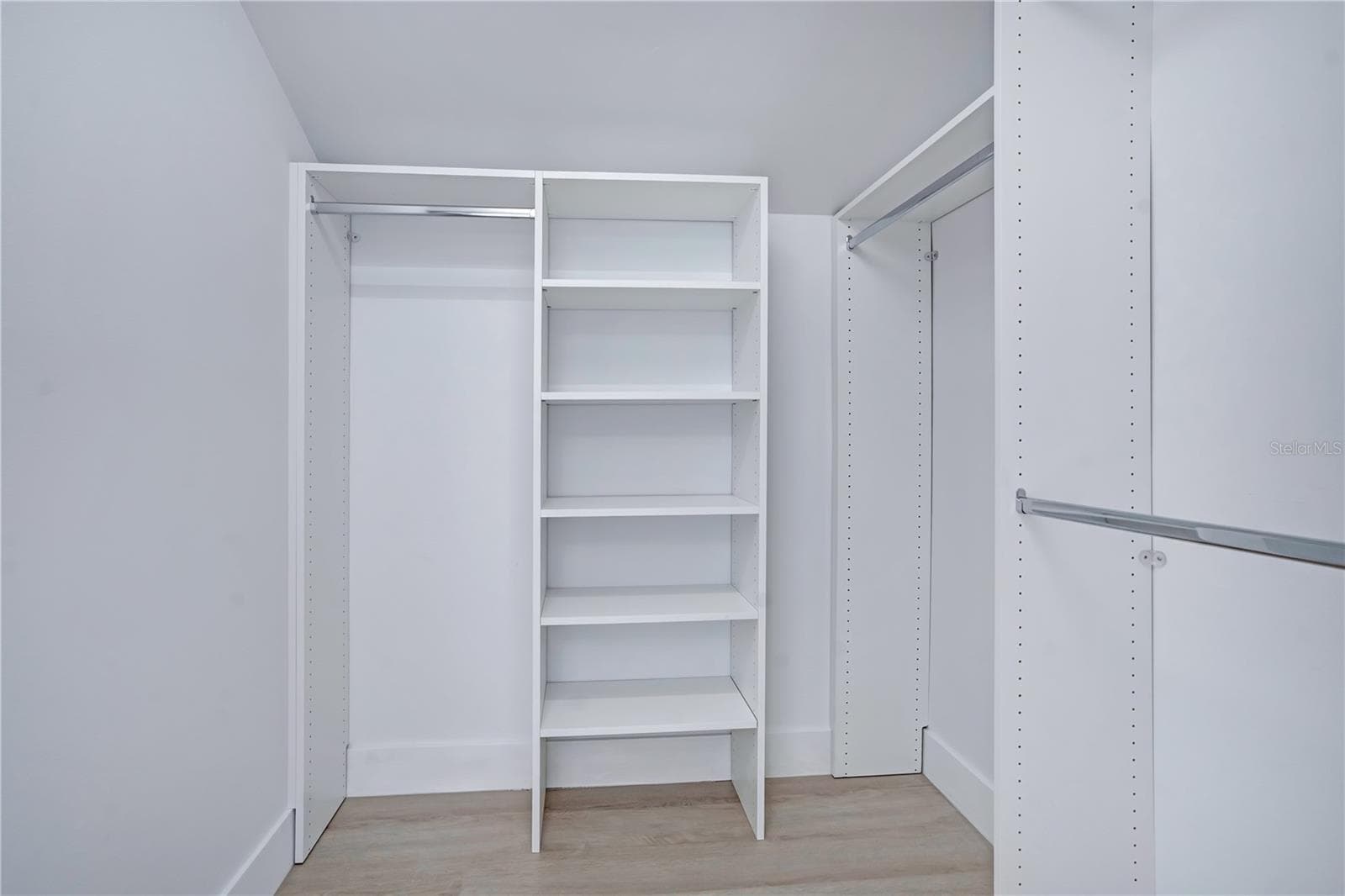 Custom closet featuring built-in shelving and multiple hanging areas. - 3012 S SEMORAN BLVD #G2, ORLANDO