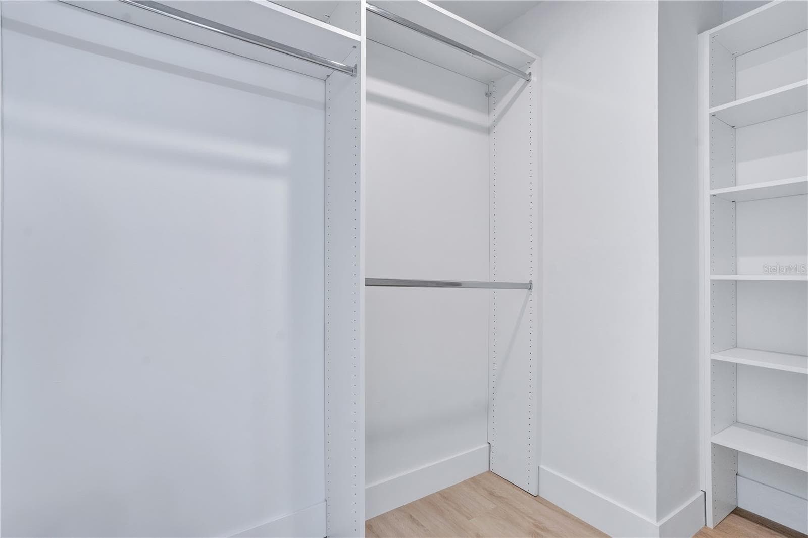 Custom closet featuring built-in shelving and multiple hanging areas. - 3012 S SEMORAN BLVD #G2, ORLANDO