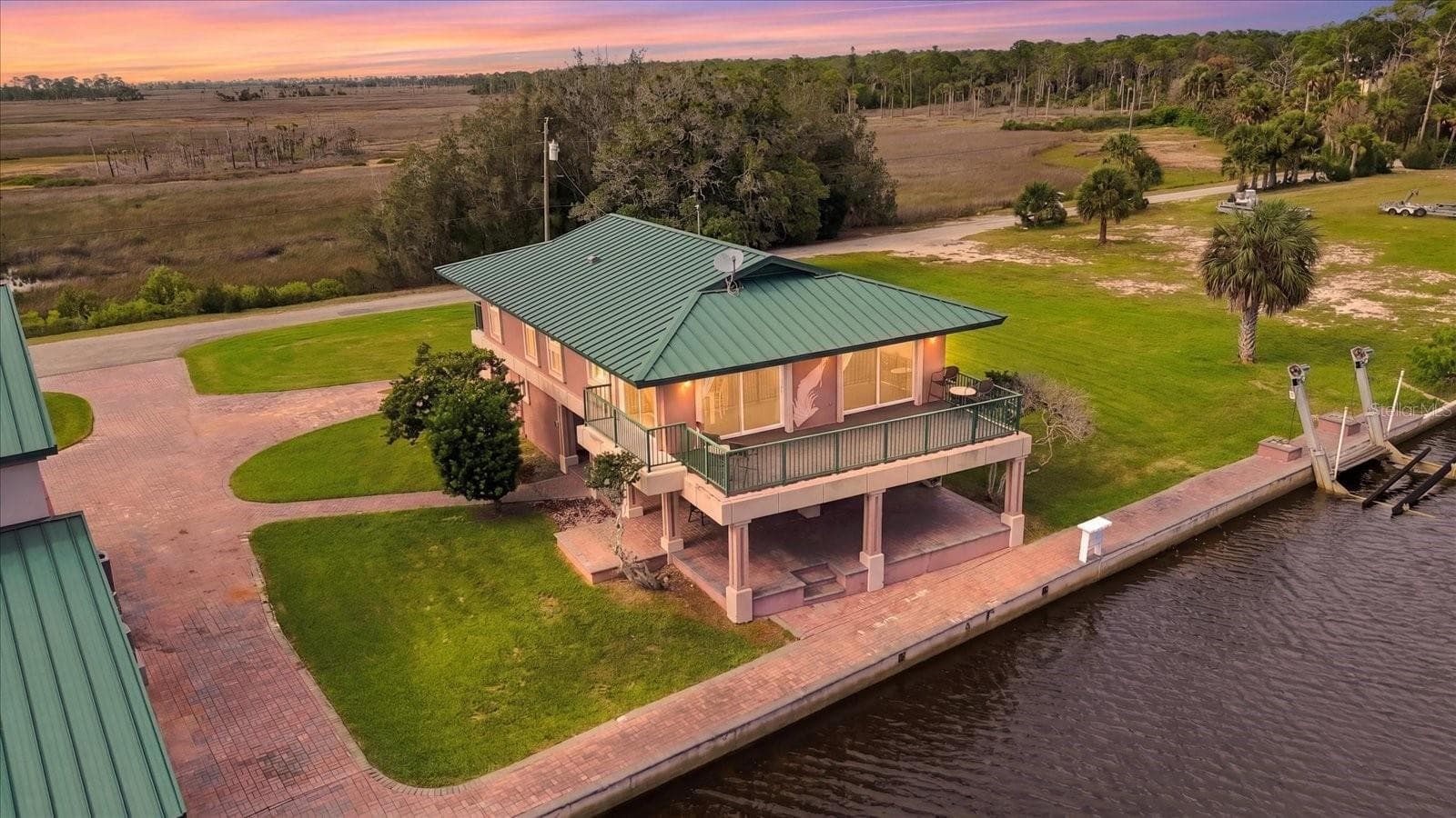Twilight aerial showing the residence, waterfront, and surrounding grounds. - 3198 INDIAN GULF LN, HERNANDO BEACH