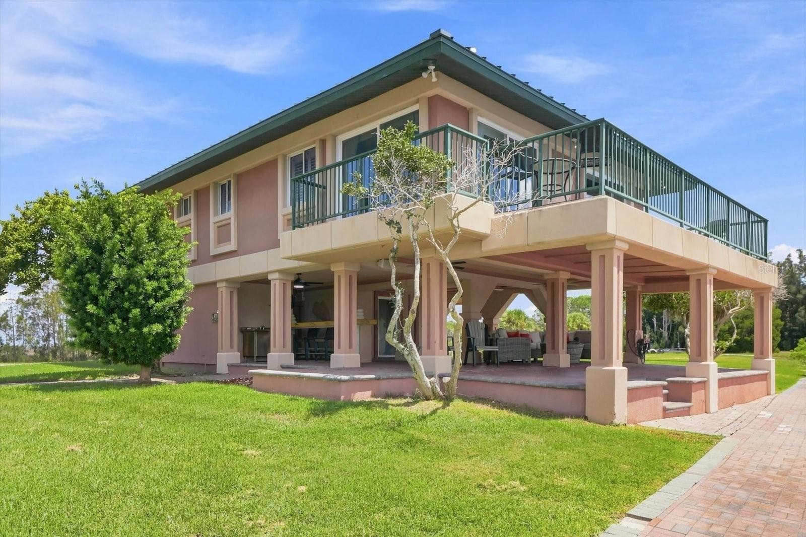 Waterfront-side exterior highlighting the expansive covered outdoor entertaining space. - 3198 INDIAN GULF LN, HERNANDO BEACH