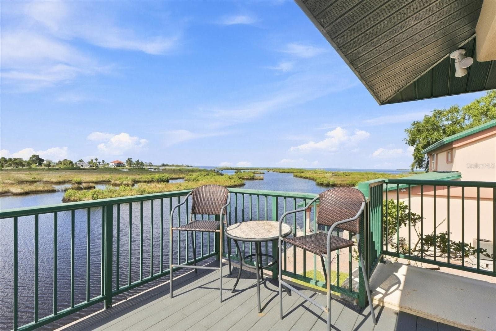Balcony seating overlooking the water and natural coastal landscape. - 3198 INDIAN GULF LN, HERNANDO BEACH