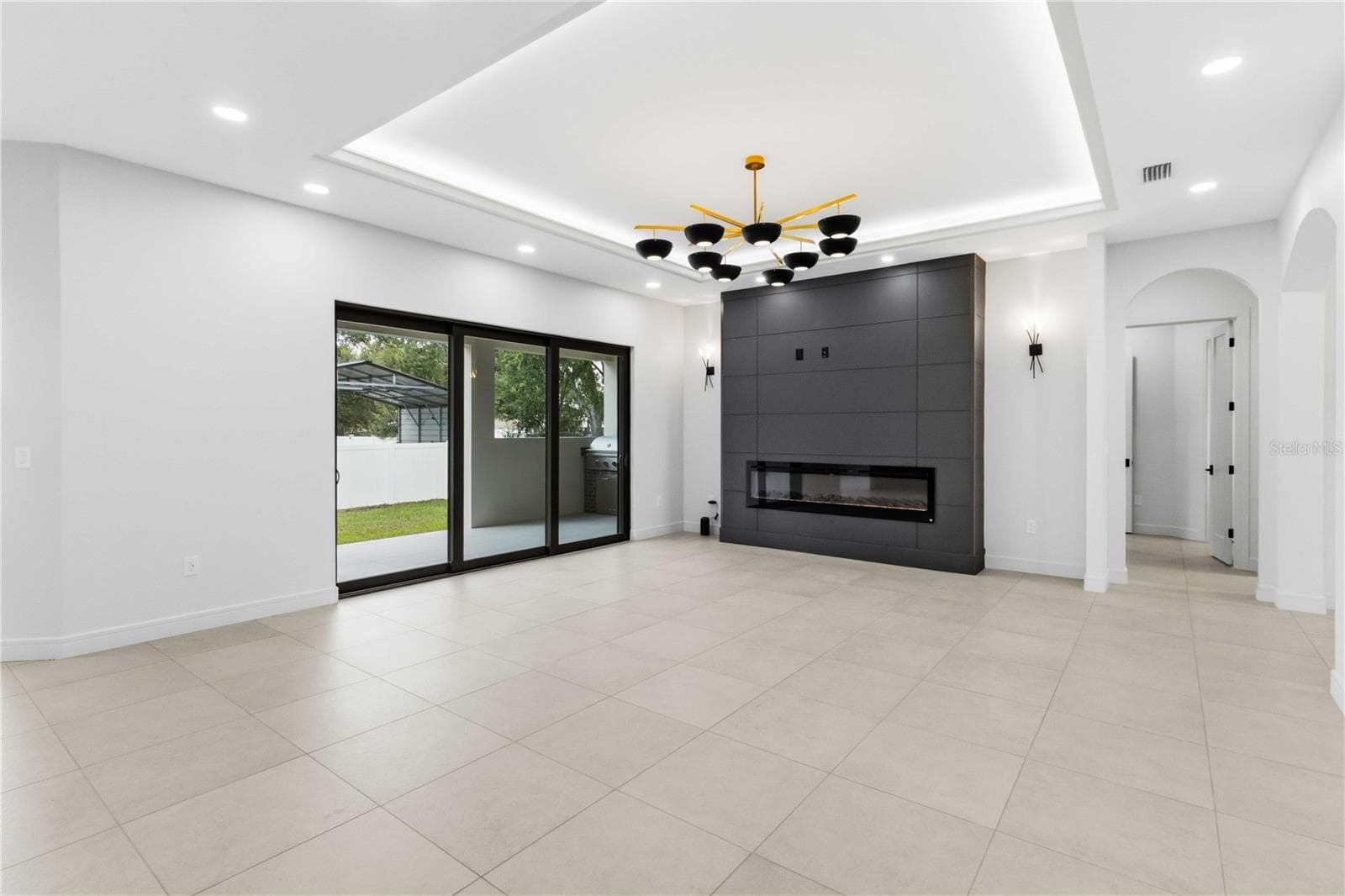 sleek linear fireplace and floor-to-ceiling accent wall of living room - 104 S MAKI RD, PLANT CITY