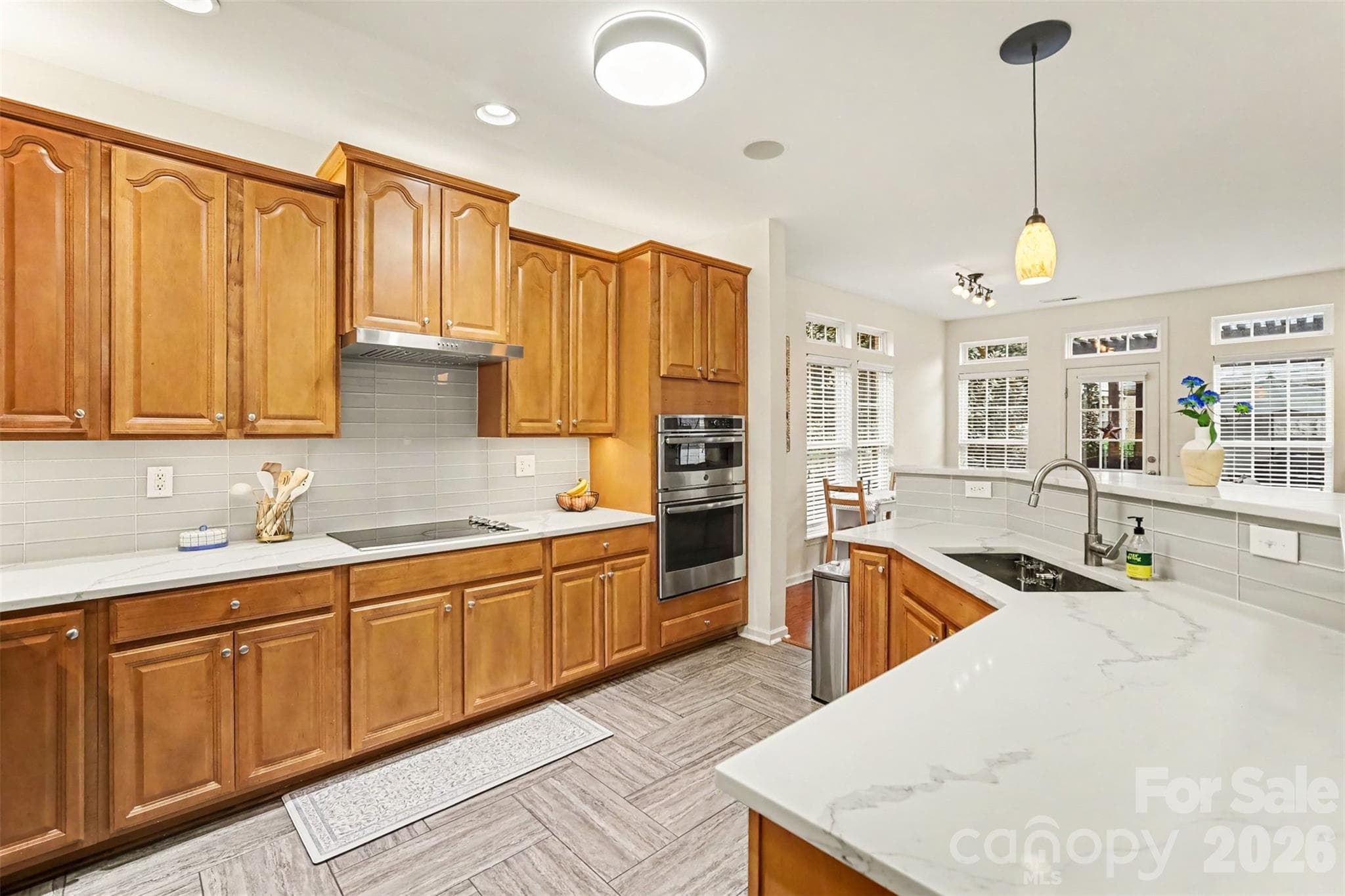 Open kitchen with Quartz counters,updated backsplash, stainless farm style sink, loads of cabinet space - 438 Magnolia Street, Davidson