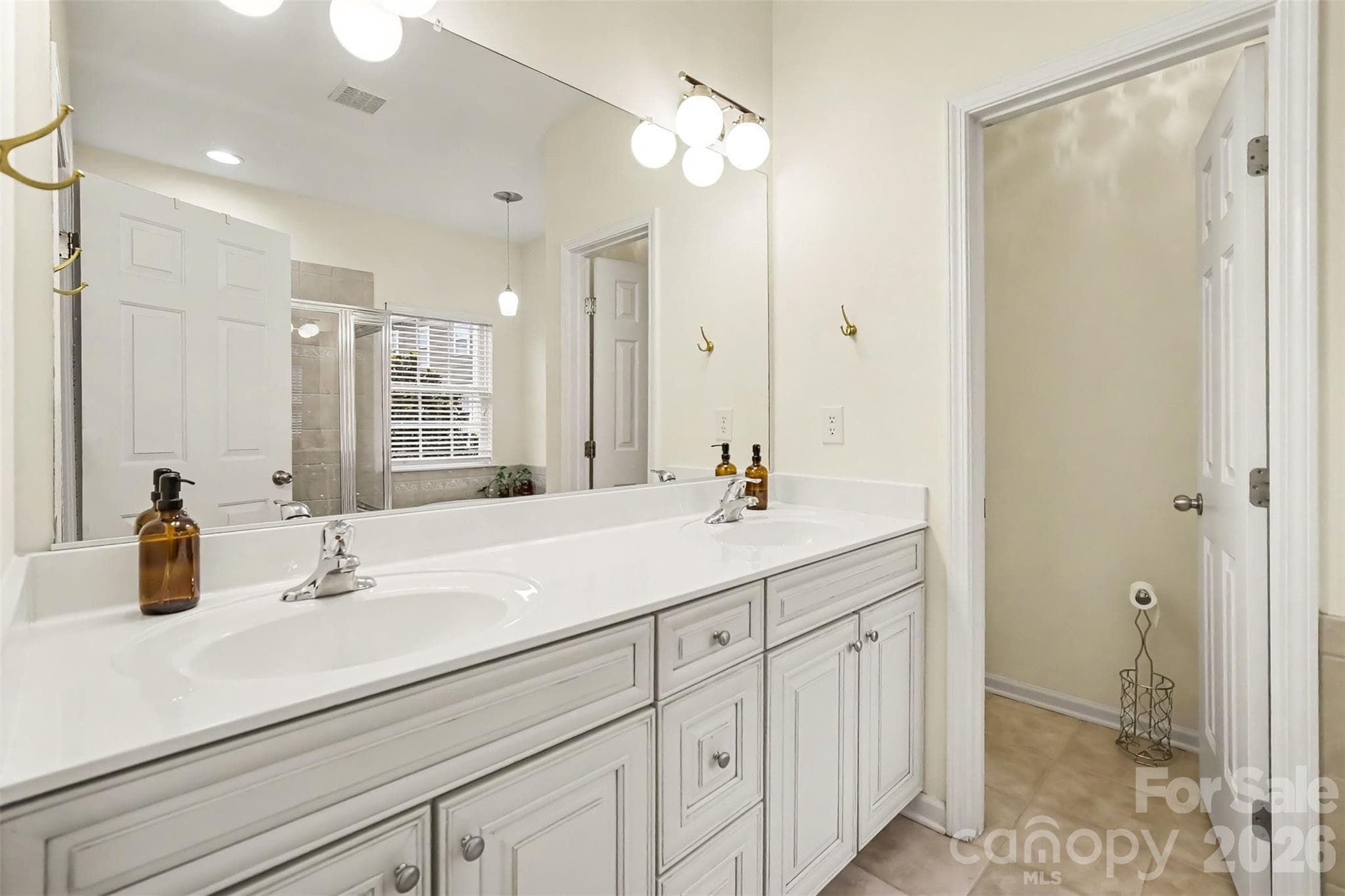 Primary bath with dual vanity, tile flooring, neutral colors - 438 Magnolia Street, Davidson