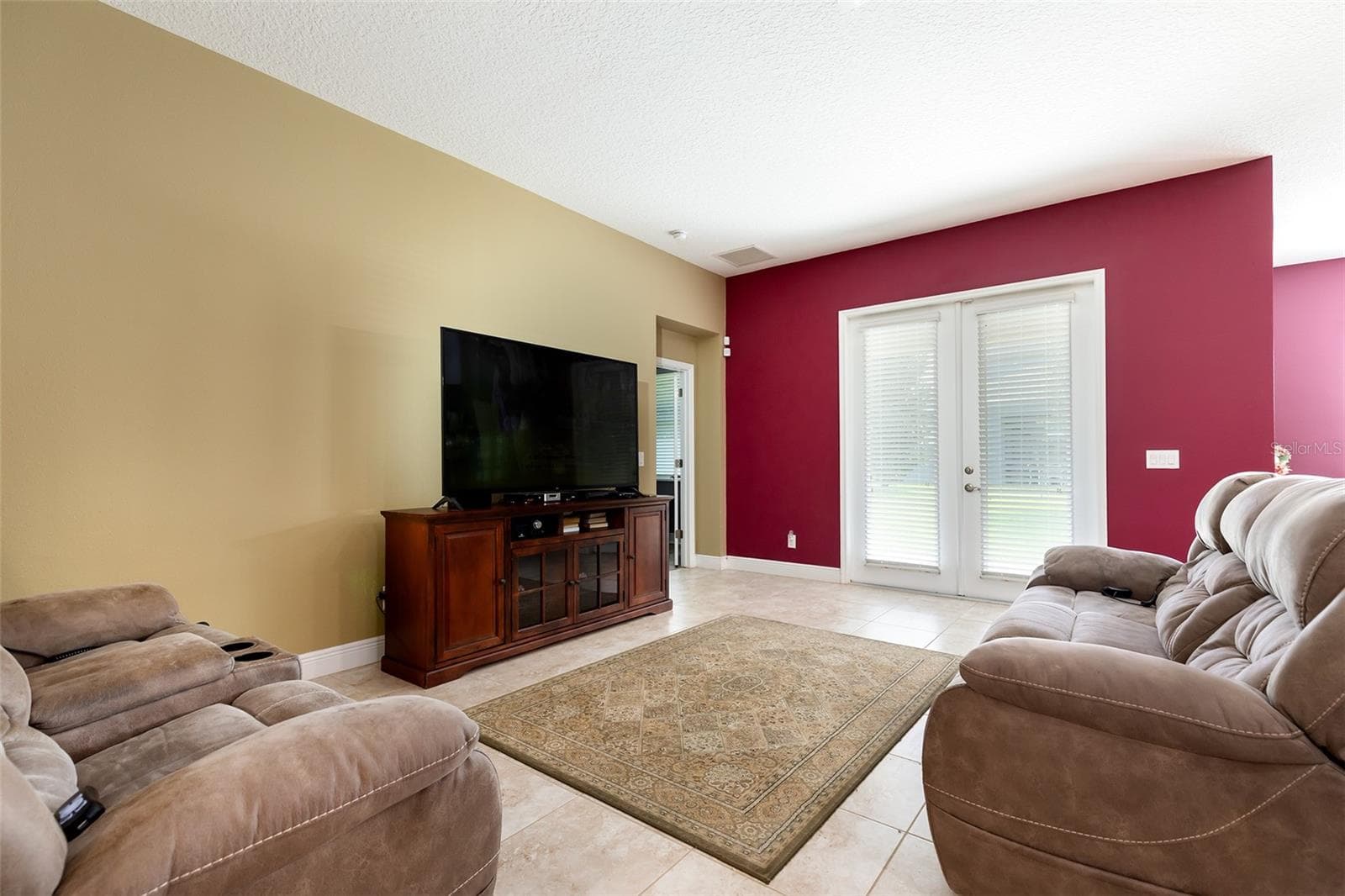 Living room with French doors leading to the back lanai - 995 KARST TREE LN, APOPKA