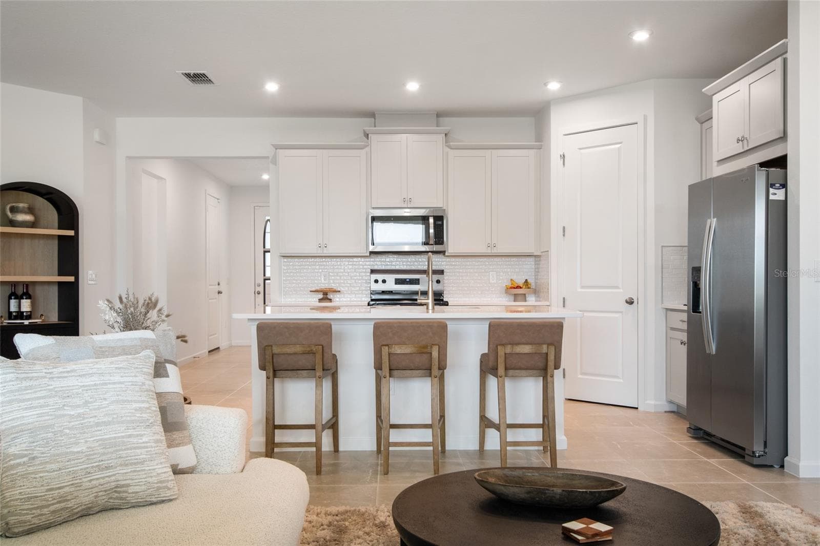 Refreshing white cabinets topped with crown molding, dedicated refrigerator built in topped with storage cabinets area just a few of these upgraded features in the kitchen area. - 2685 SWEET ACACIA DR, CLERMONT