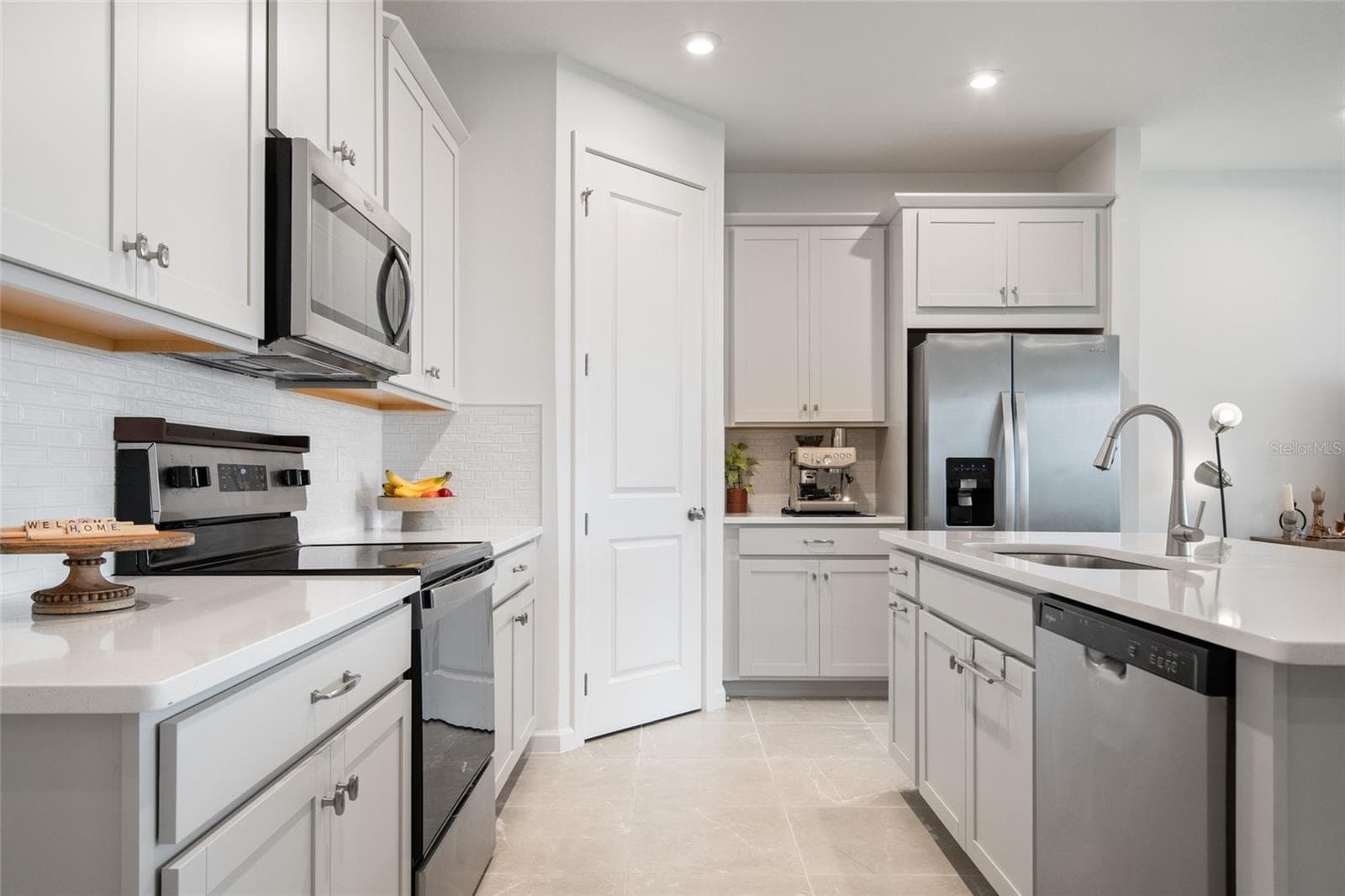 transitional tile back splash, stainless steel appliances only 18 months old and plenty of prep space on the counters made of quartz. - 2685 SWEET ACACIA DR, CLERMONT