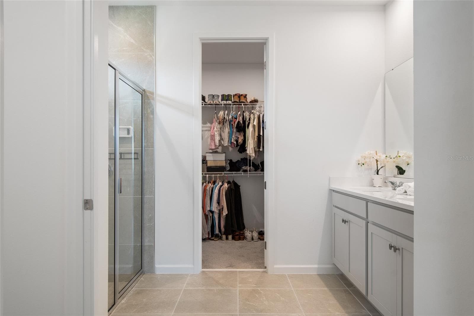 Upon entering you realize the primary bathroom is expansive. A double vanity with storage, walk in shower and huge walk in closet at the end of the bathroom. - 2685 SWEET ACACIA DR, CLERMONT