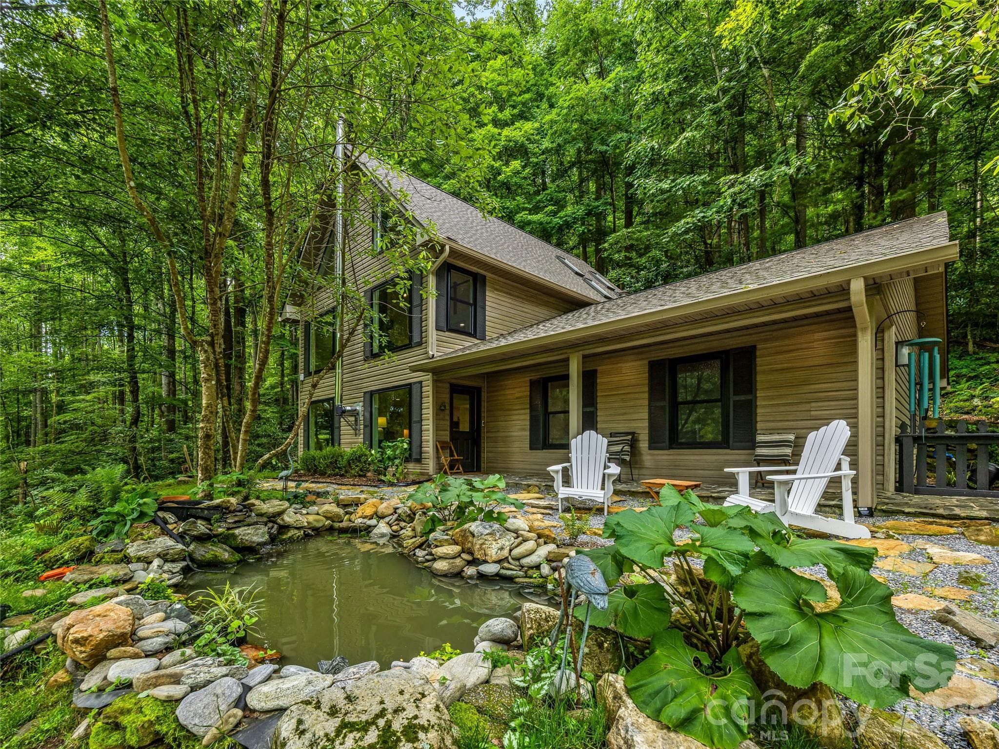 A tranquil fishpond and natural stone and landscaping create a peaceful welcome beneath the surrounding forest canopy. - 81 Summer Trees Lane, Burnsville