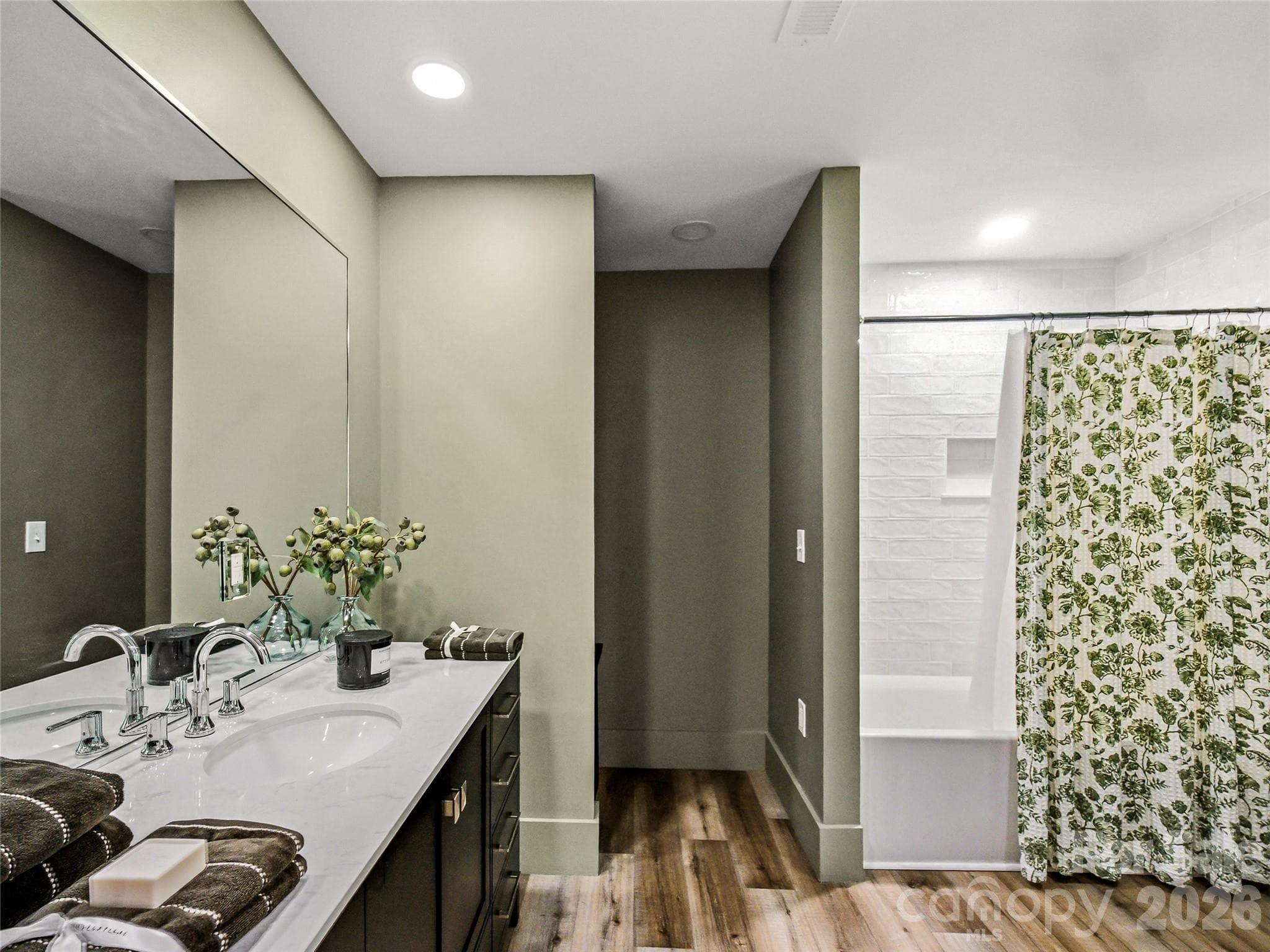 Updated first-floor bathroom featuring a tub/shower combination and a conveniently located laundry nook. - 81 Summer Trees Lane, Burnsville