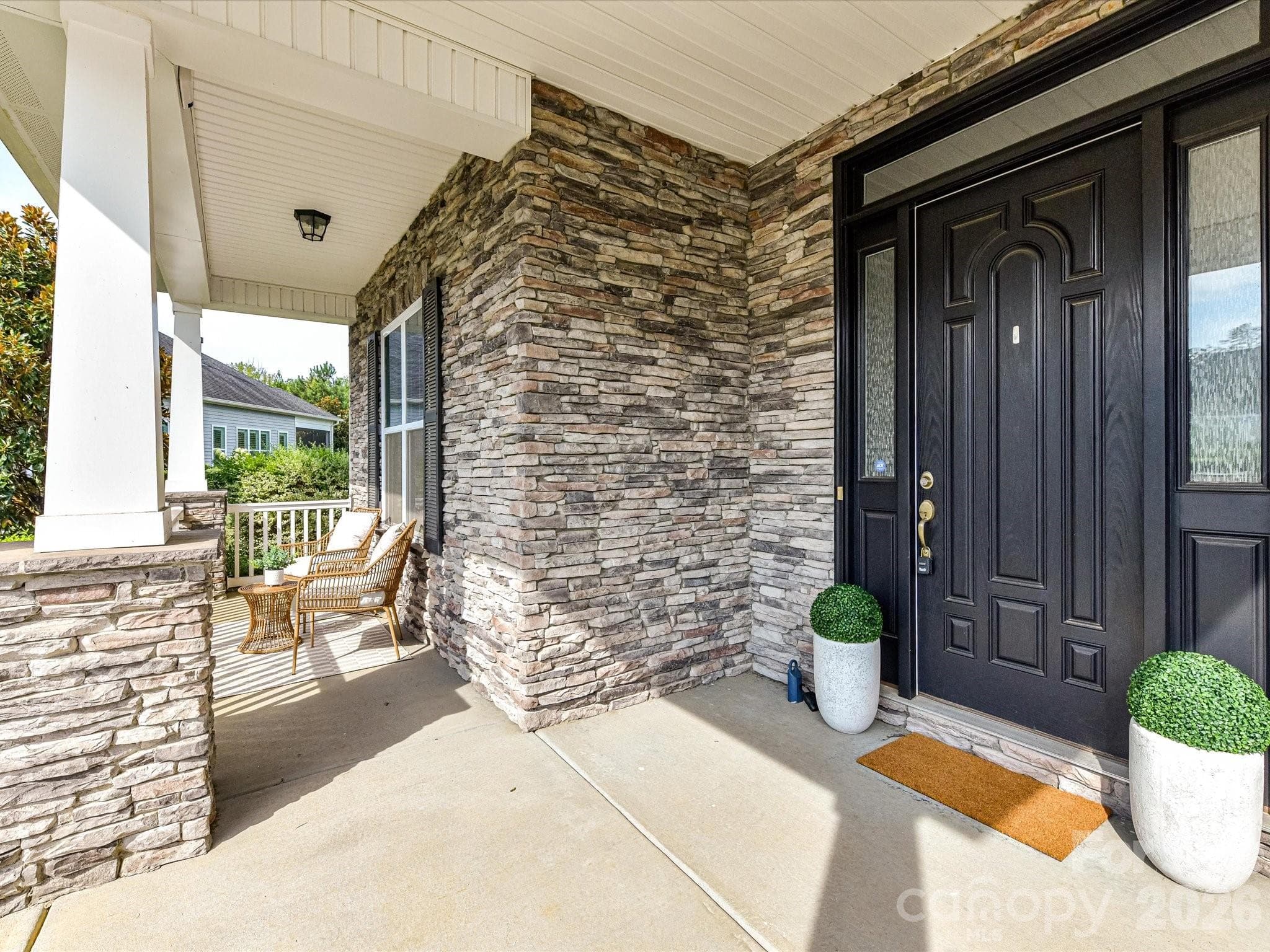 Welcoming covered front porch features handsome stone accents and plenty of space to relax and enjoy the outdoors. - 13003 Riley Grace Lane, Cornelius