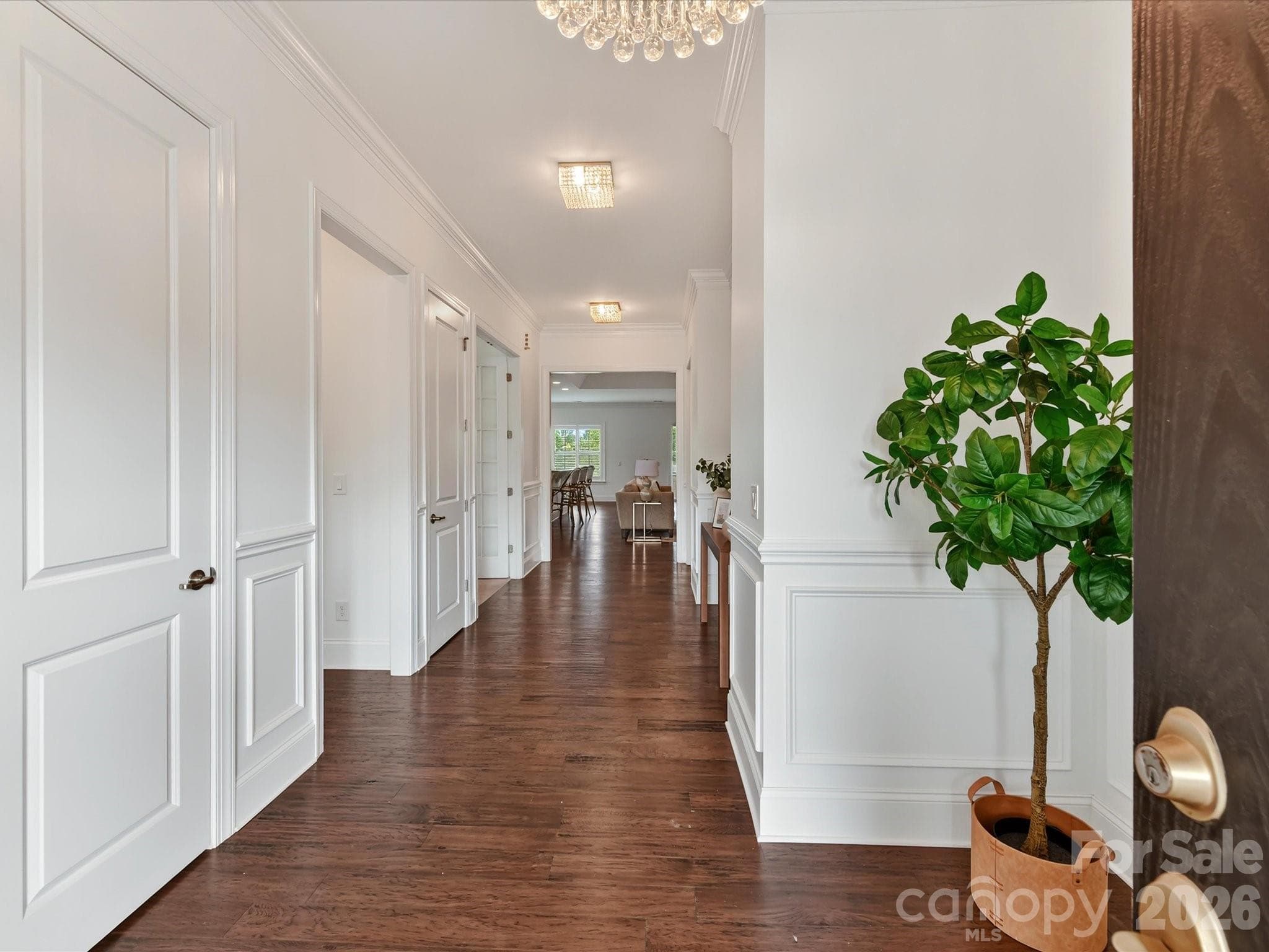 Welcoming entryway features beautiful flooring, elegant wall molding, crown molding, and stylish lighting that sets the tone for the home. - 13003 Riley Grace Lane, Cornelius