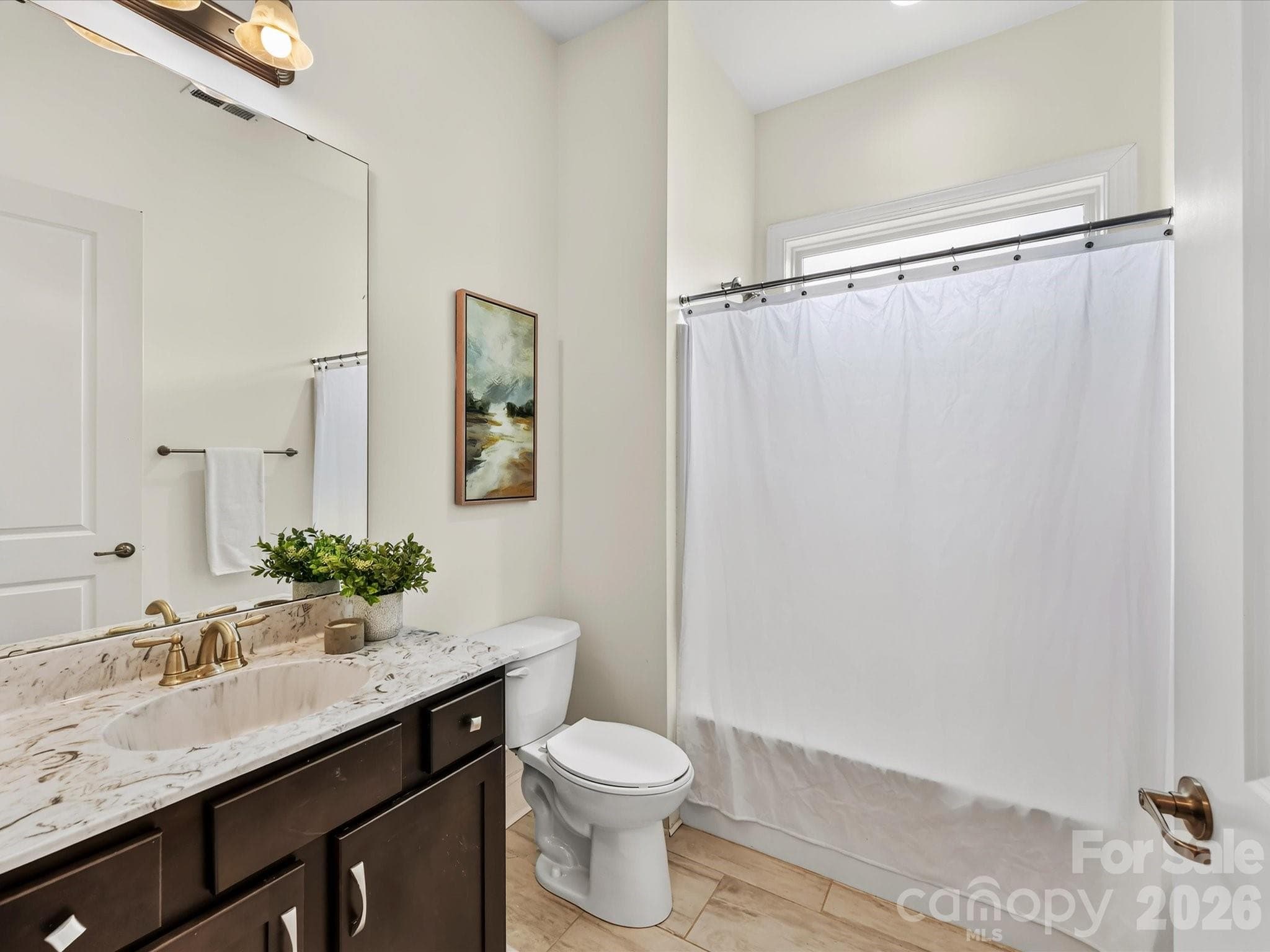 Full bath features a spacious vanity with ample storage, decorative countertop, tub/shower combination, and natural light. - 13003 Riley Grace Lane, Cornelius
