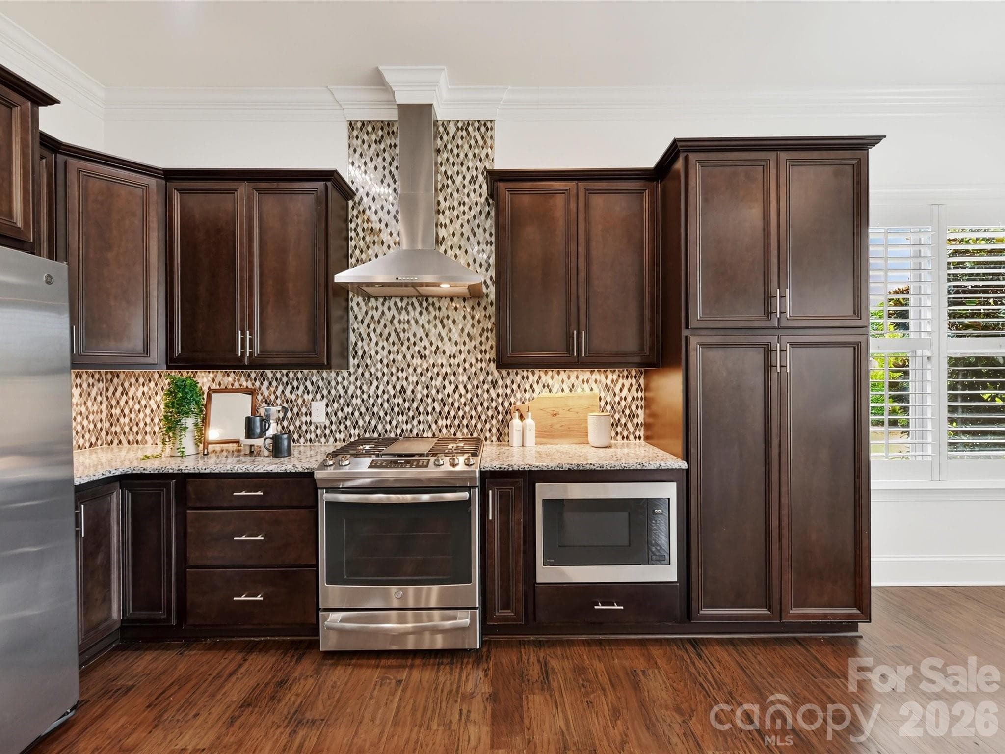 Kitchen flows seamlessly into the bright breakfast nook, where abundant windows and open sightlines create an inviting space for casual dining. - 13003 Riley Grace Lane, Cornelius