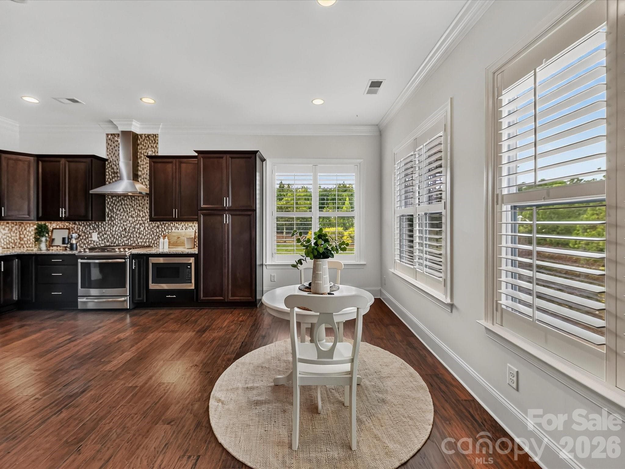 Kitchen flows seamlessly into the bright breakfast nook, where abundant windows and open sightlines create an inviting space for casual dining. - 13003 Riley Grace Lane, Cornelius