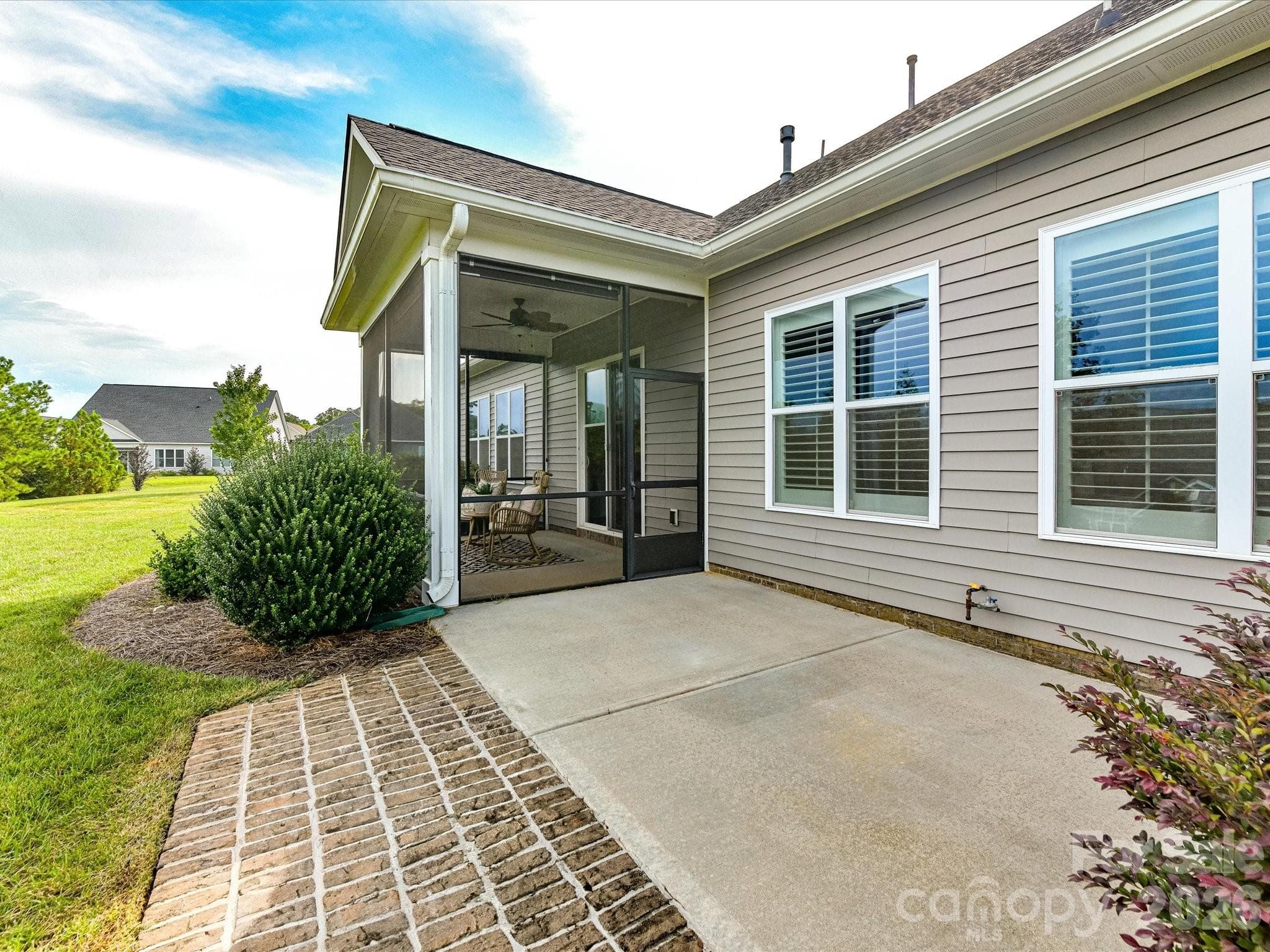 Screened porch opens to an extended patio, creating versatile outdoor living and entertaining space overlooking the landscaped backyard. - 13003 Riley Grace Lane, Cornelius