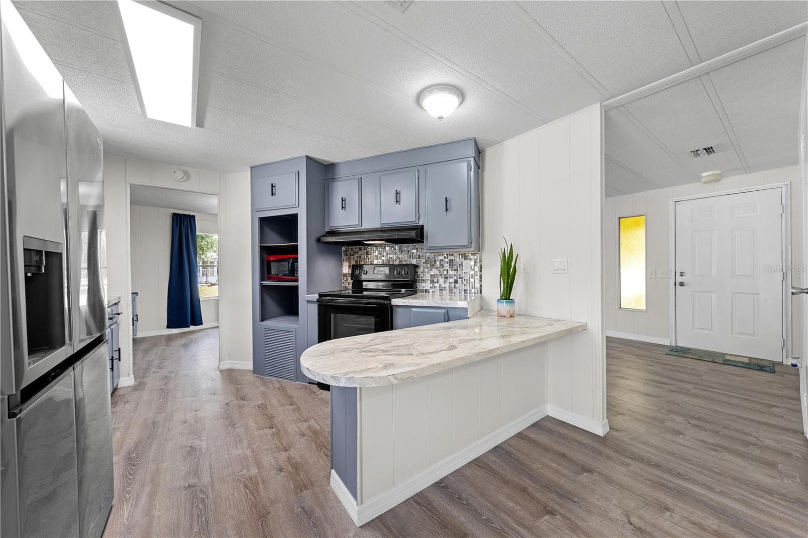 View from family room into kitchen, dining and front entry - 5601 LAKE LIZZIE DR, ST CLOUD