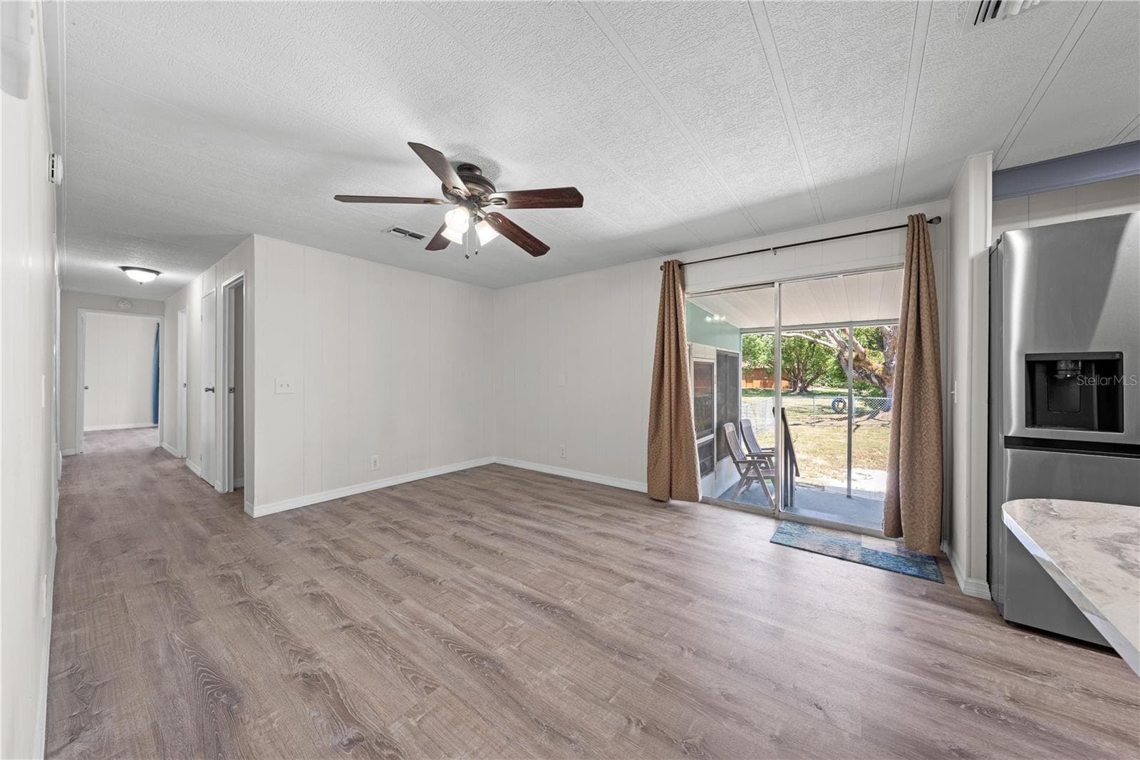 Flex family room that could be used as a game room, office, guest space, playroom or to expand the size of the kitchen. Sliders provide ez access to carport and fenced area for pets. - 5601 LAKE LIZZIE DR, ST CLOUD