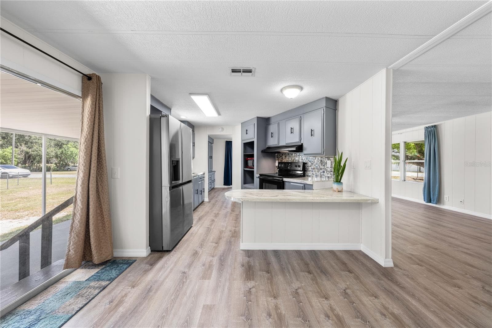 View from flex family room into kichen, dining, living room and outside carport. Don't miss the breakfast bar! - 5601 LAKE LIZZIE DR, ST CLOUD