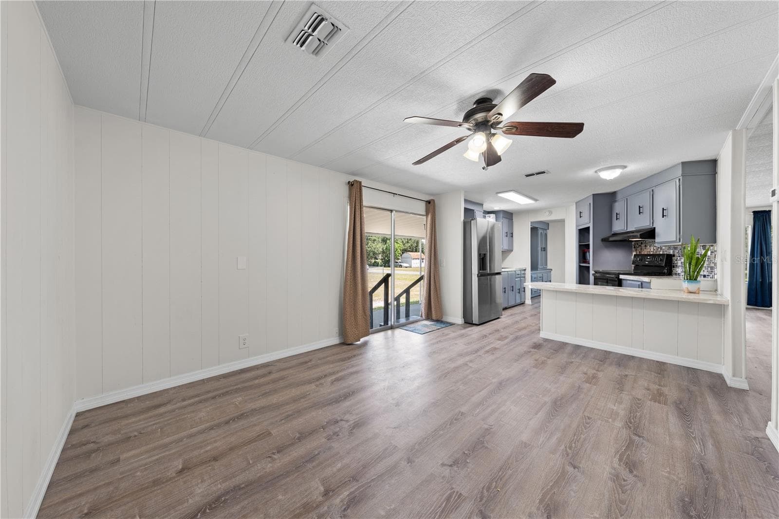 View of flex family room and kitchen from hallway. - 5601 LAKE LIZZIE DR, ST CLOUD