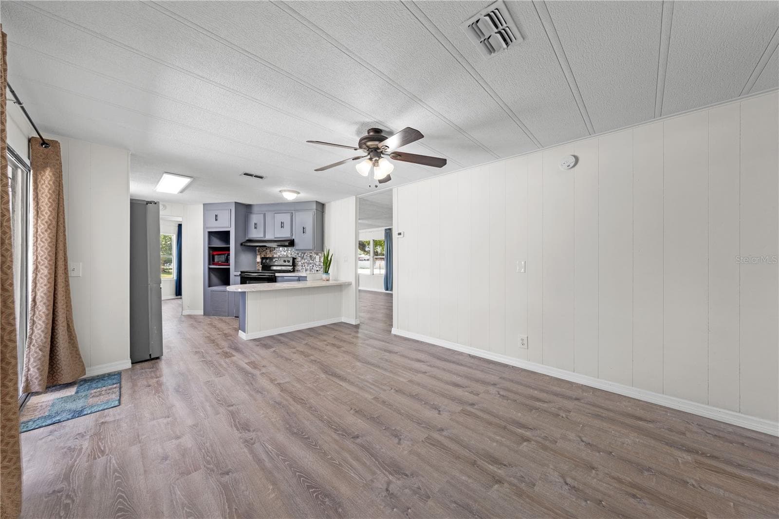 Family room peeking into kitchen, living and dining areas - 5601 LAKE LIZZIE DR, ST CLOUD