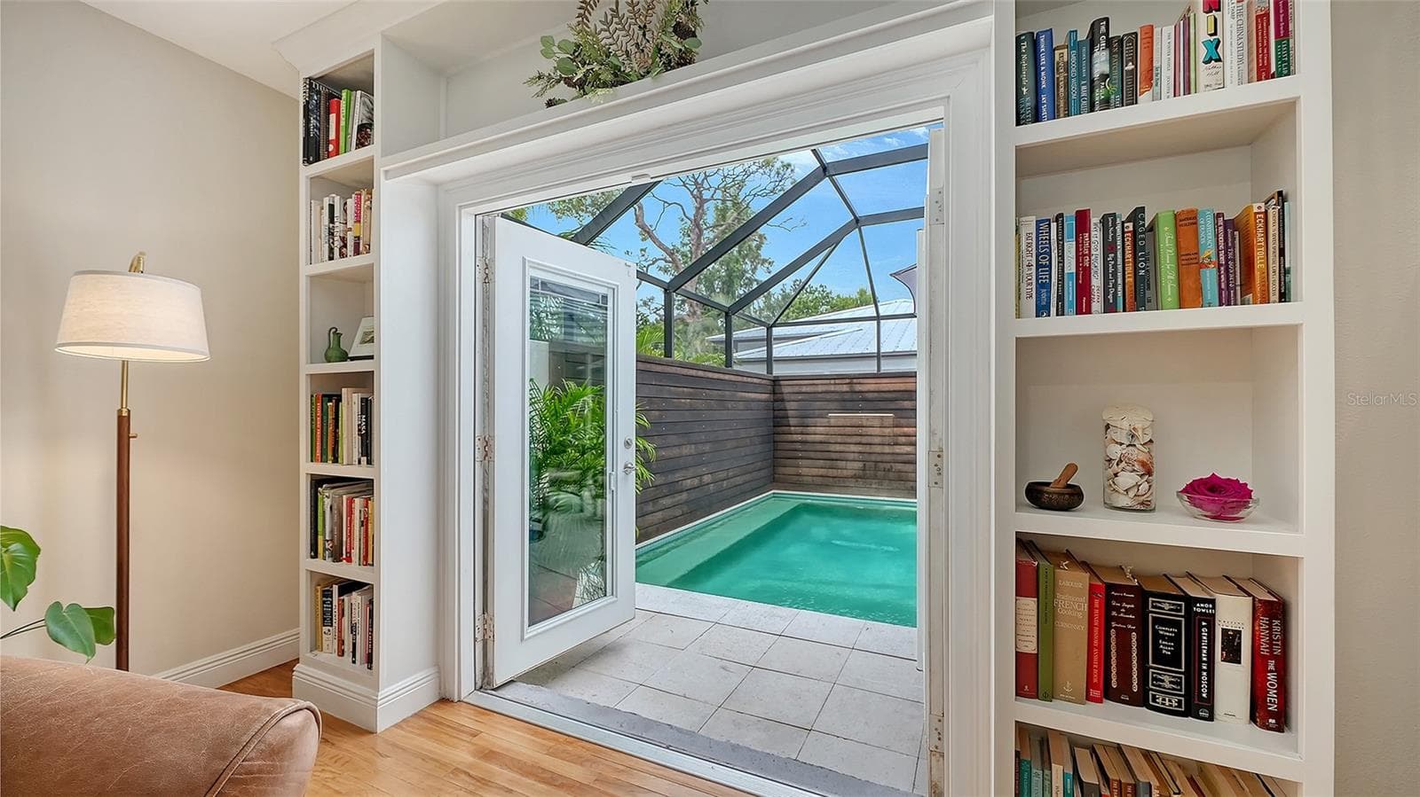 Custom French doors provide a beautiful visual connection from the interior living space to the private heated pool and screened courtyard. - 1685 6TH ST, SARASOTA
