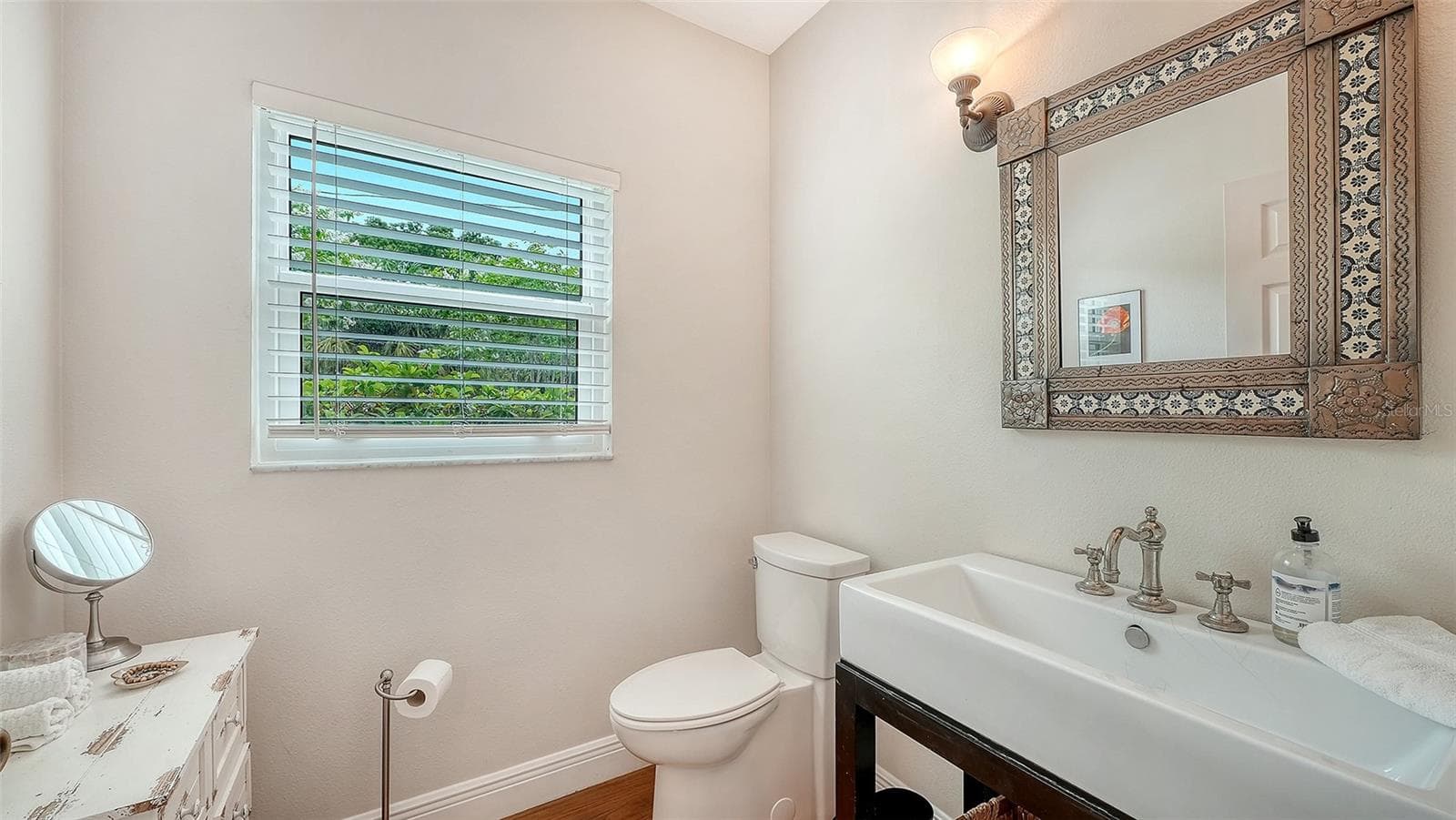 Convenient half bath showcases elevated finishes and thoughtful design consistent with the home’s sophisticated renovation. - 1685 6TH ST, SARASOTA